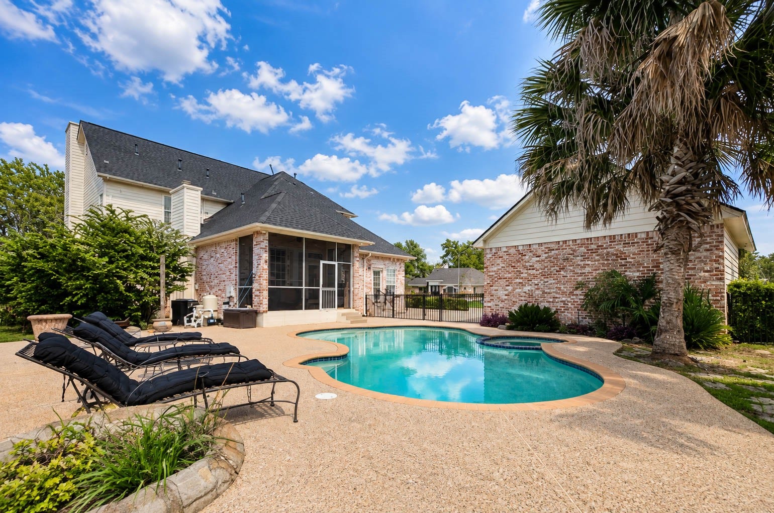 33103 Whickham Circle, Fulshear, TX 77441 The private backyard retreat is centered around a sparkling freeform pool surrounded by expansive decking and mature tropical landscaping. Multiple lounging areas, a screened porch, and the surrounding architecture create an impressive resort-inspired setting.