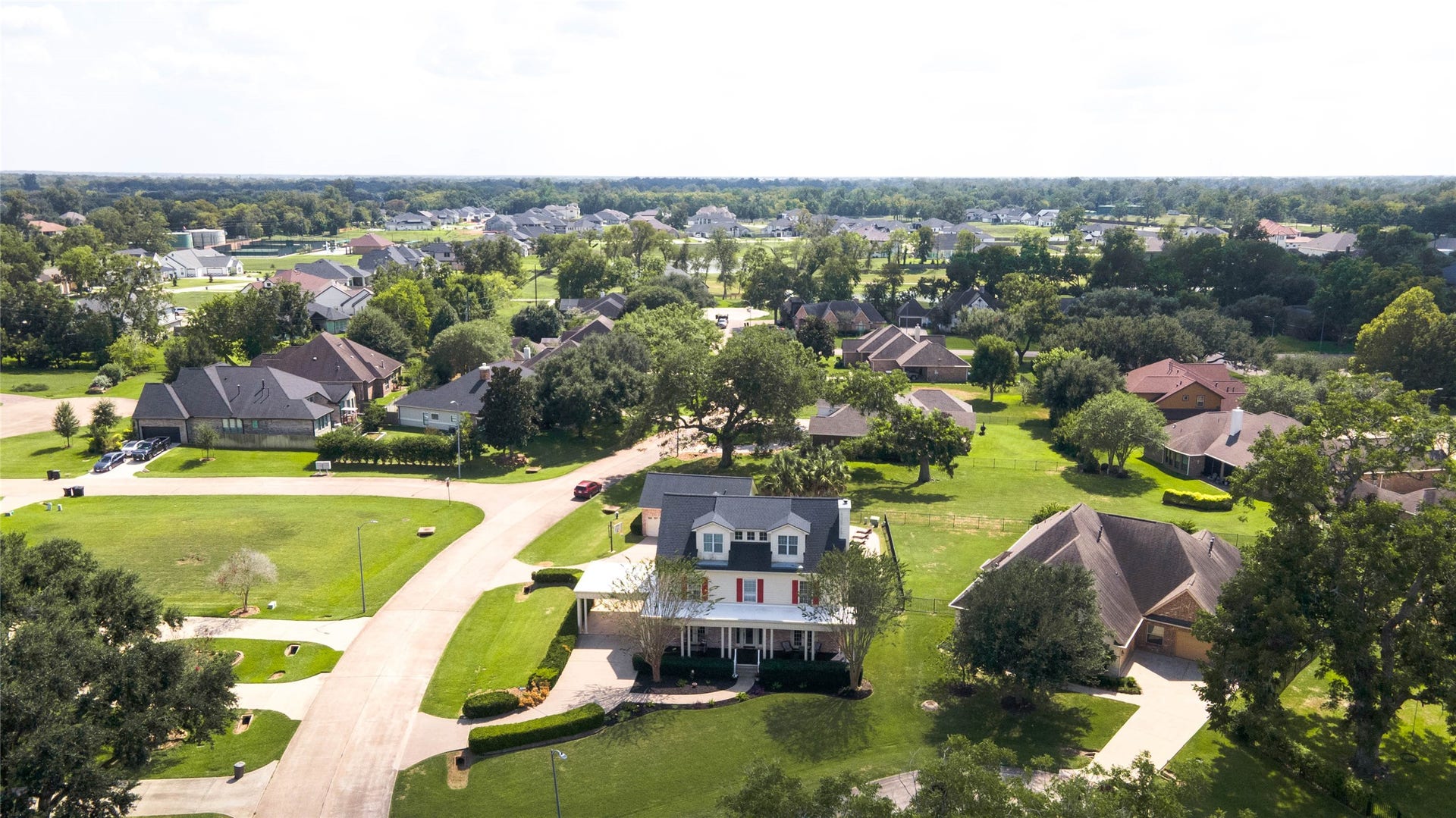 33103 Whickham Circle, Fulshear, TX 77441 An elevated perspective showcases the residence among an established collection of homes surrounded by mature trees and expansive lawns.