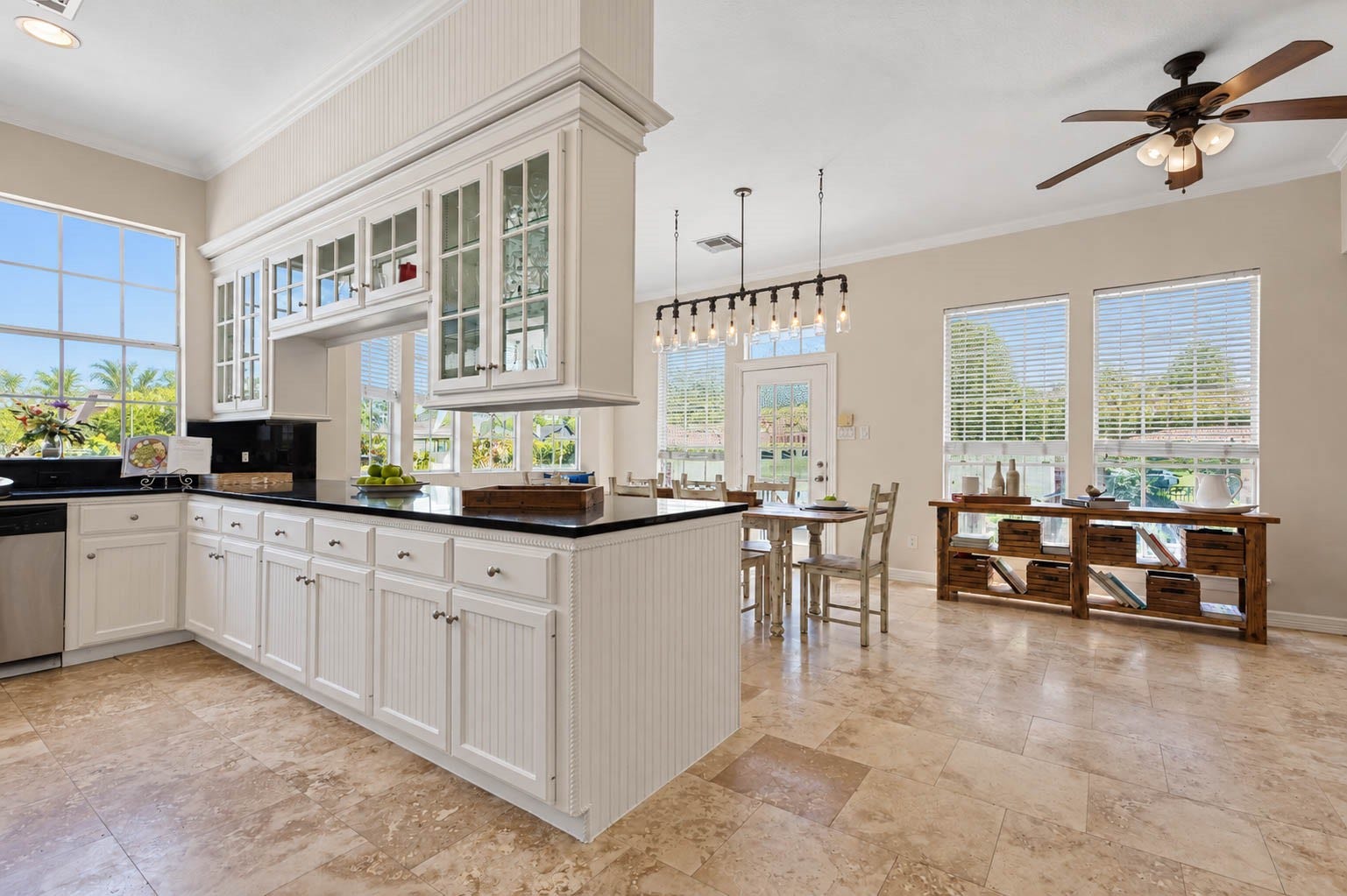 33103 Whickham Circle, Fulshear, TX 77441 Custom white cabinetry makes a striking statement with elegant glass-front upper display cabinets, detailed millwork, & abundant storage. Just beyond, the light-filled breakfast area creates an inviting extension of the kitchen.