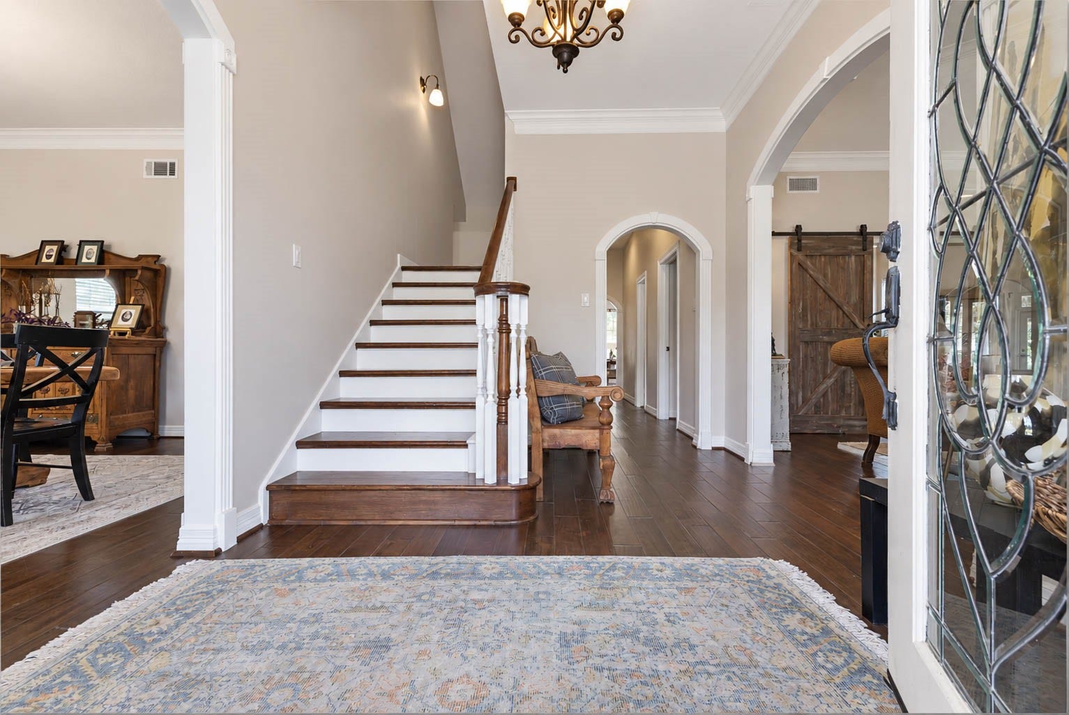 33103 Whickham Circle, Fulshear, TX 77441 The welcoming entry introduces rich hardwood flooring, high ceilings, crown molding, and a beautifully detailed staircase. Arched openings provide architectural definition and establish an elegant transition into the surrounding formal and living spaces.