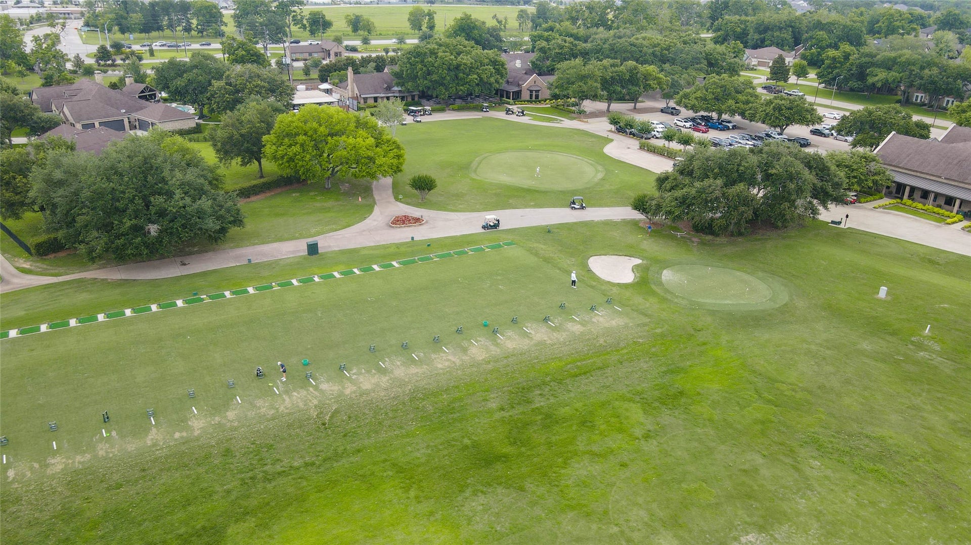 33103 Whickham Circle, Fulshear, TX 77441 This aerial view showcases part of the golf course practice area, featuring manicured greens, driving stations, and professionally maintained fairways.