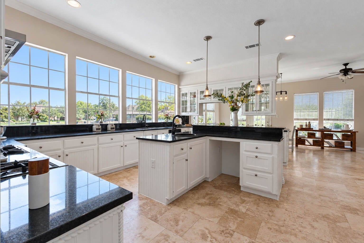 33103 Whickham Circle, Fulshear, TX 77441 Walls of oversized windows are a standout feature of this bright kitchen, bringing in exceptional natural light and creating picturesque views from the main workspace. An expansive stretch of granite countertops, abundant cabinetry, multiple sinks, and a central prep area provide substantial room for cooking and gathering.
