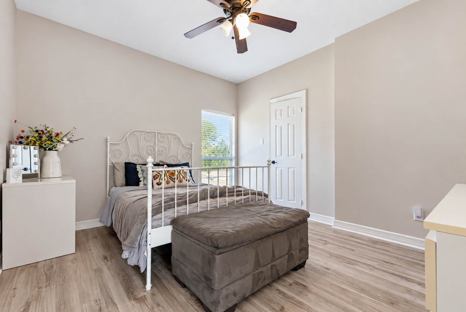 33103 Whickham Circle, Fulshear, TX 77441 This spacious secondary bedroom features high ceilings with a ceiling fan, neutral finishes, & warm wood-look flooring. A tall window fills the room with natural light, while a generous walk-in closet provides ample storage. Well-proportioned dimensions allow for a variety of furniture arrangements.