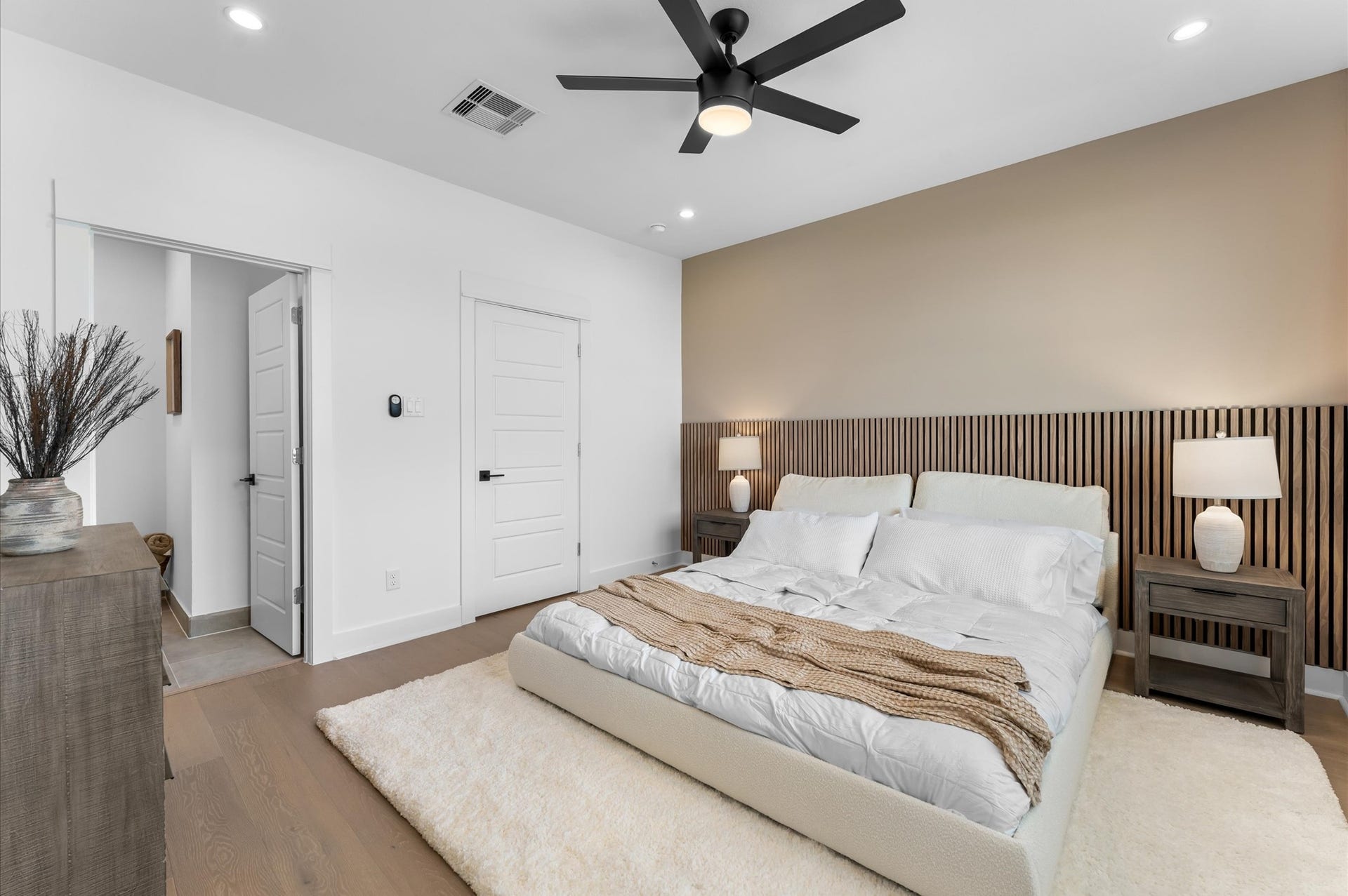 The luxurious primary ensuite features sleek modern finishes, a glass-enclosed shower with stylish tile, and a double-sink vanity topped with quartz countertops, complemented by two contemporary mirrors and lighting fixtures, creating a bright, elegant, and functional retreat.