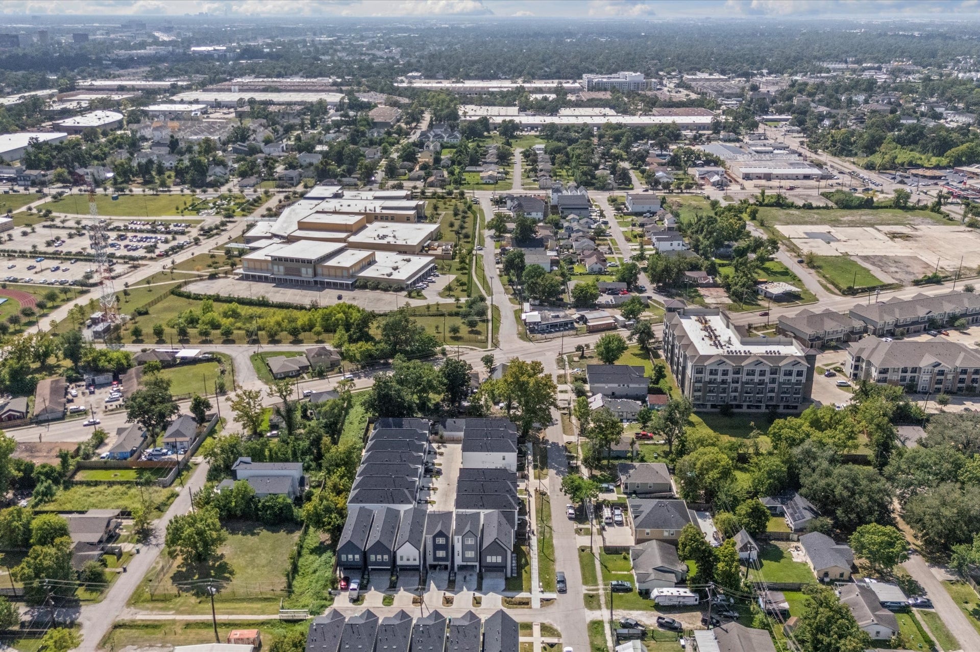 This stunning aerial view highlights the communitys prime location, showcasing surrounding streets, nearby amenities, and the neighborhoods layout, giving a clear perspective of the homes setting and its convenient, connected surroundings.