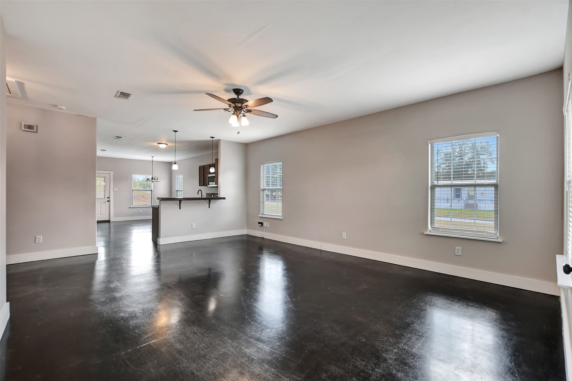 2546 16th Street, Hempstead, TX 77445 This is a spacious, open-concept living space seamlessly connects to a kitchen with a bar counter, making it ideal for entertaining. A ceiling fan provides additional comfort.