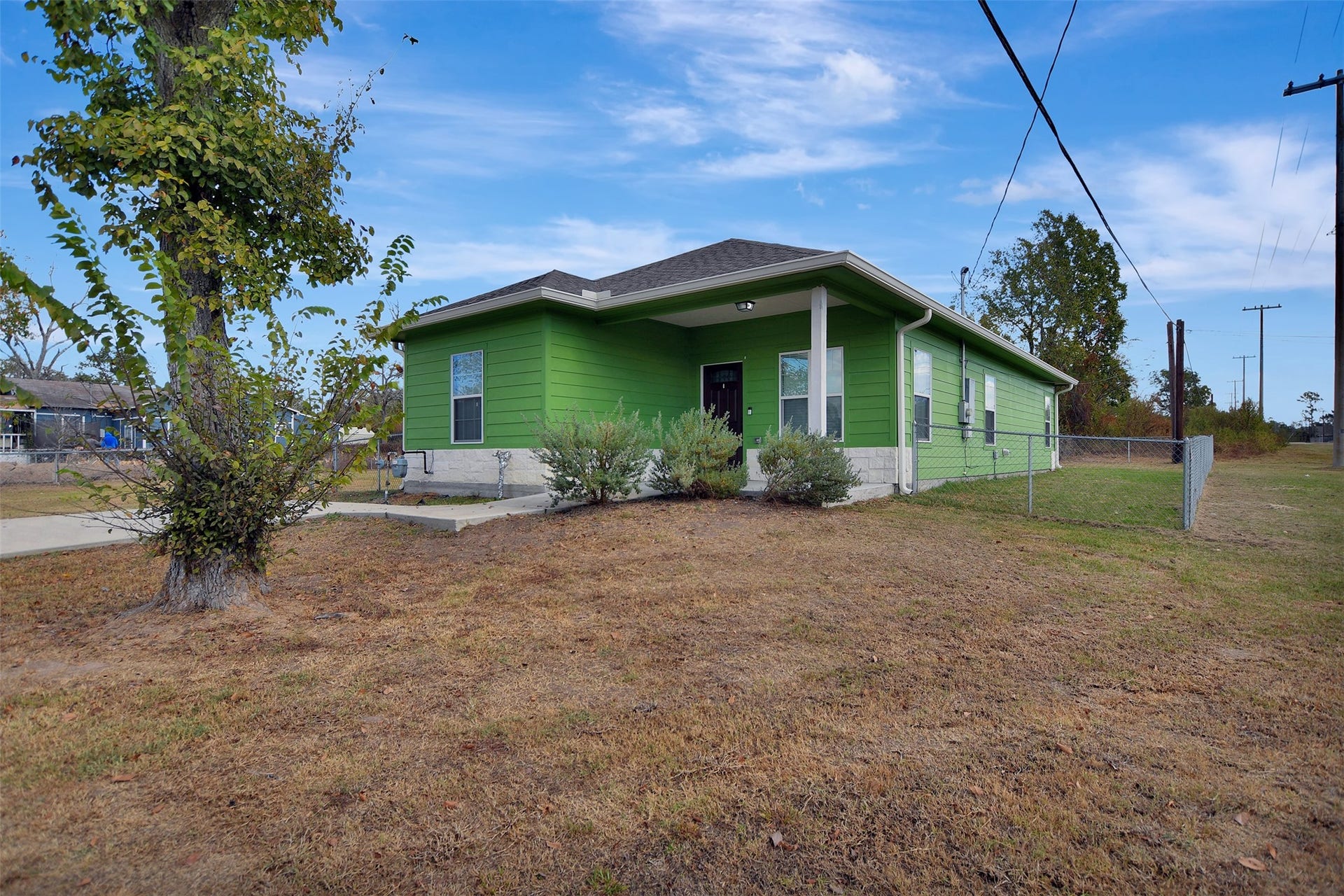 2546 16th Street, Hempstead, TX 77445 The home features a front porch and a fenced yard with some landscaping in front.