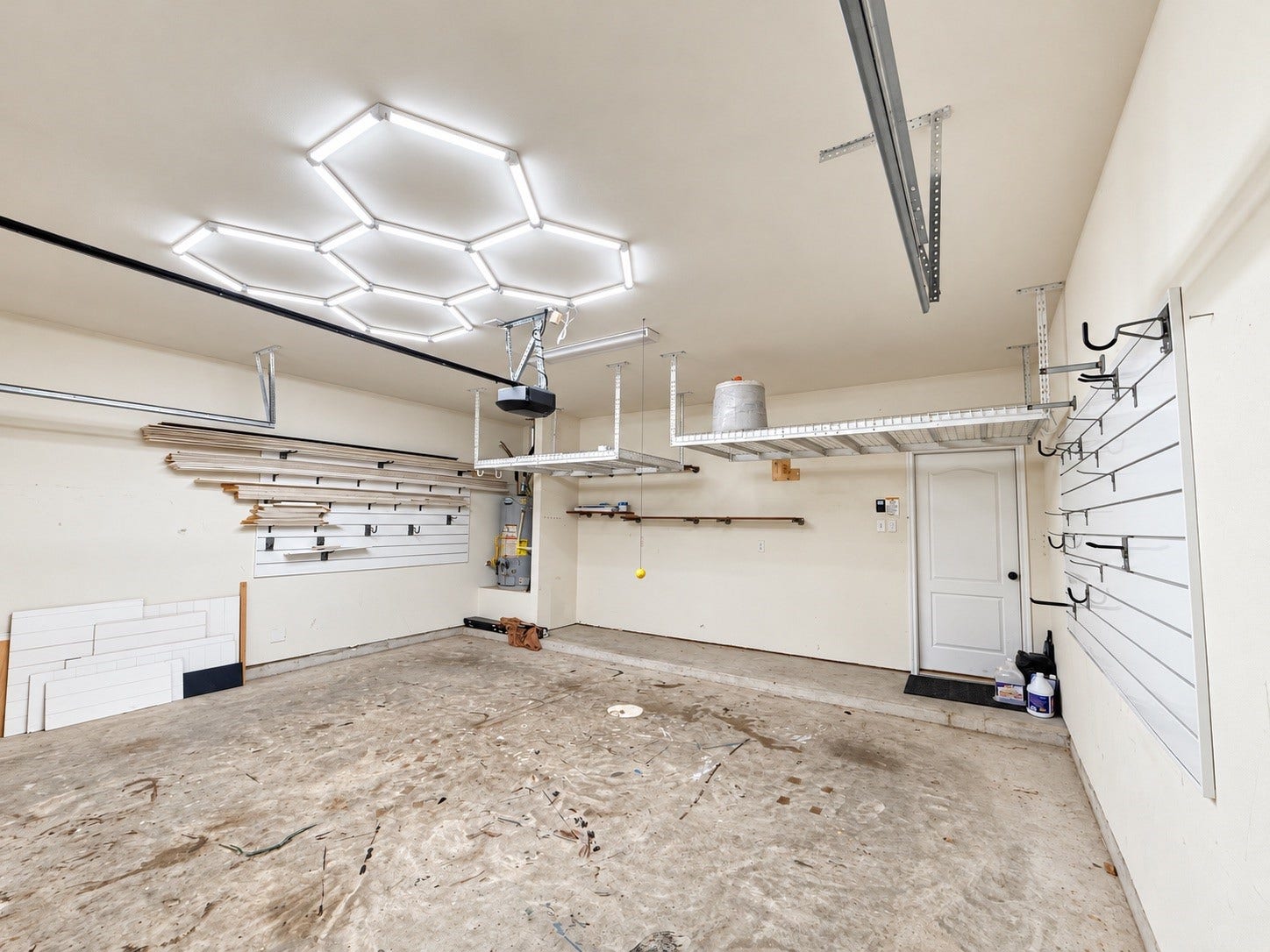 The garage features overhead storage racks, providing substantial organizational space.