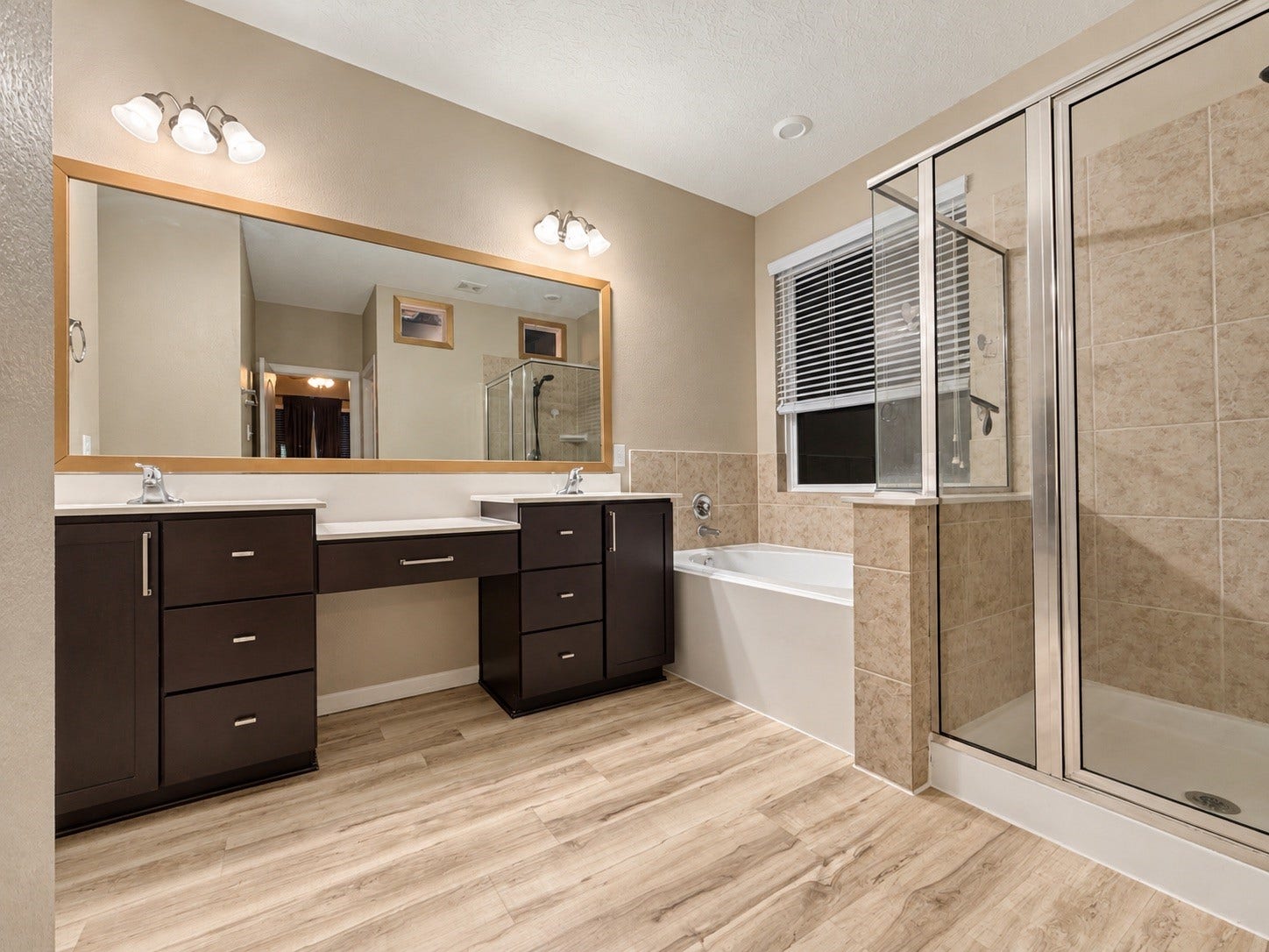 The primary bathroom offers a soaking tub and a separate shower, along with a double sink and vanity space.