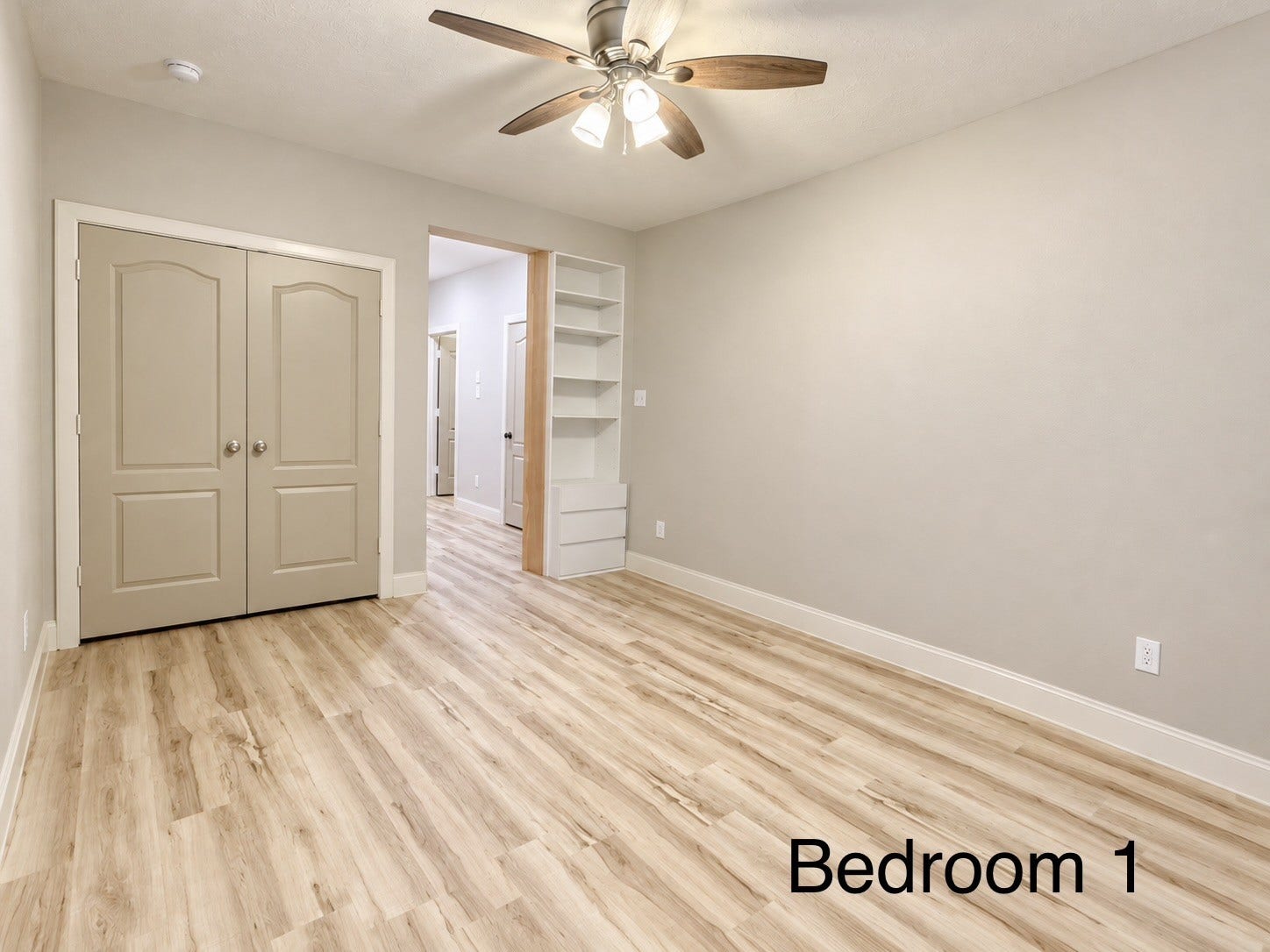 This spacious closet features double doors and built-in shelving, providing an ideal storage solution for a childs bedroom or a dedicated home office.