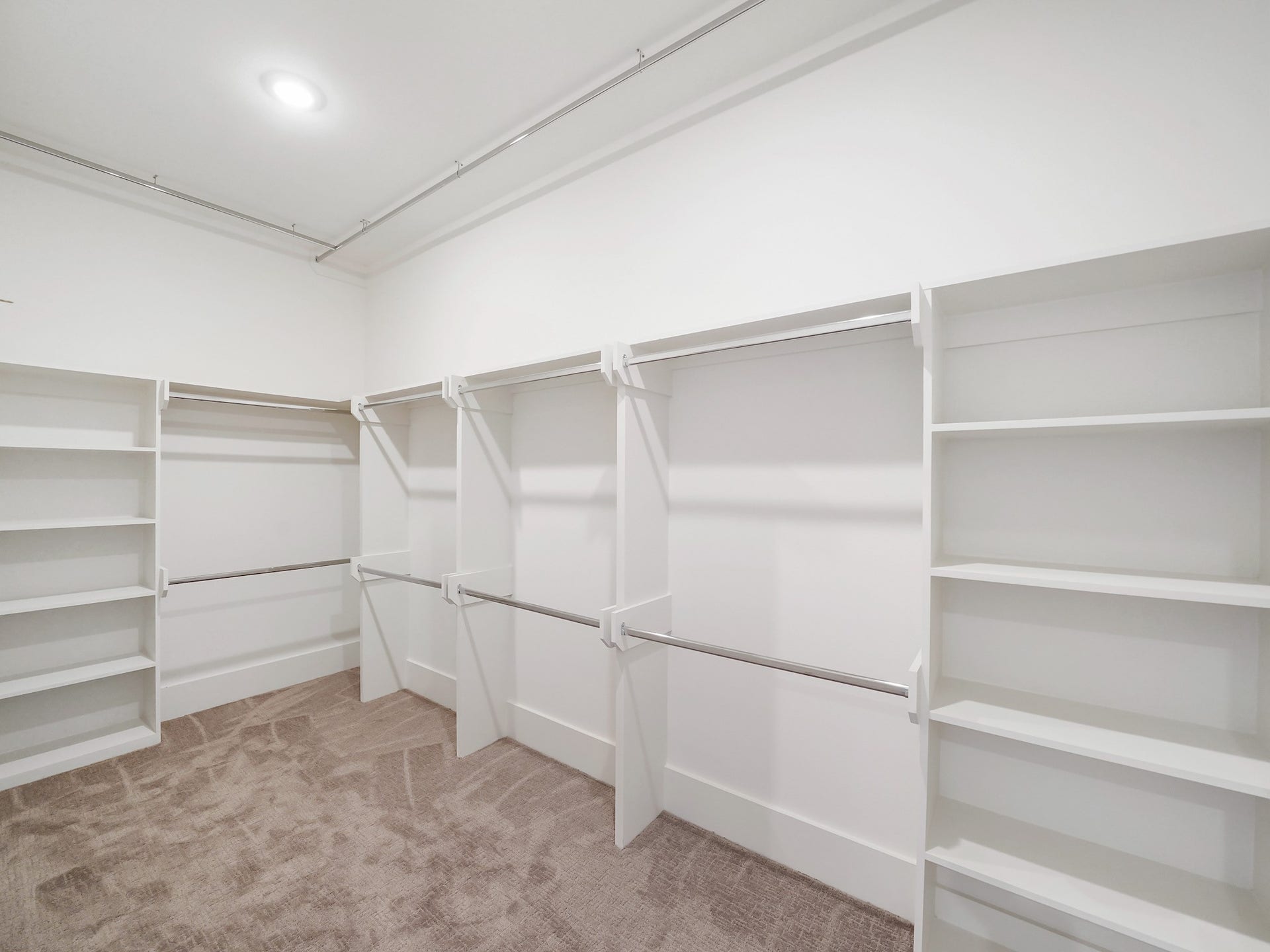 881 Rachel Street, #A, Houston, TX 77091 This photo showcases a spacious walk-in closet with multiple hanging rods and open shelving, offering ample storage space. The room is well-lit and features a neutral carpeted floor.
Photo Disclaimer: Photos are representative of the community and may depict a similar floor plan, model home, or previously completed residence.