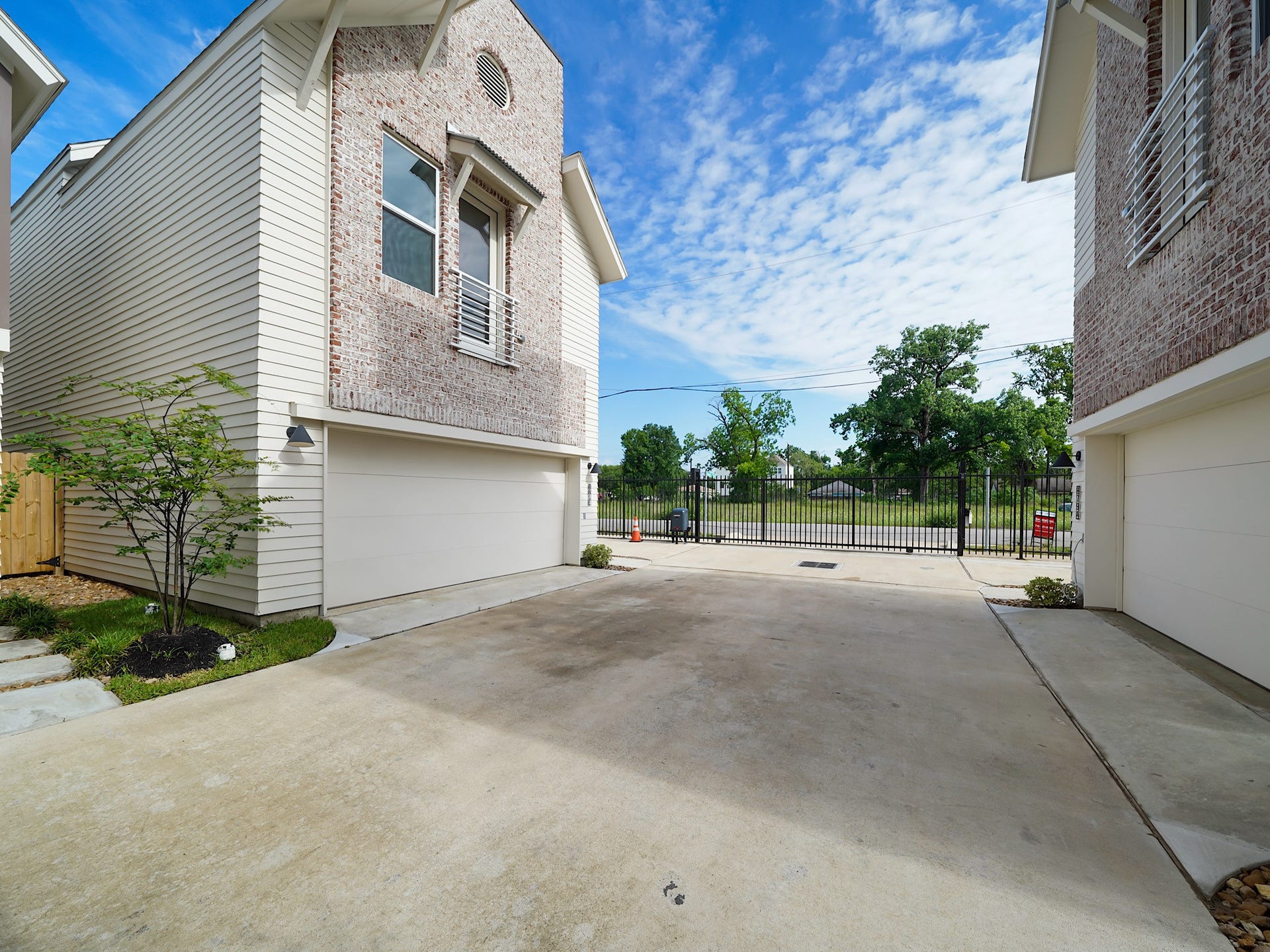 881 Rachel Street, #A, Houston, TX 77091 Modern two-story homes with brick and siding exteriors, featuring double garages. The homes are situated in a gated area with a spacious shared driveway and landscaped greenery.
Photo Disclaimer: Photos are representative of the community and may depict a similar floor plan, model home, or previously completed residence.