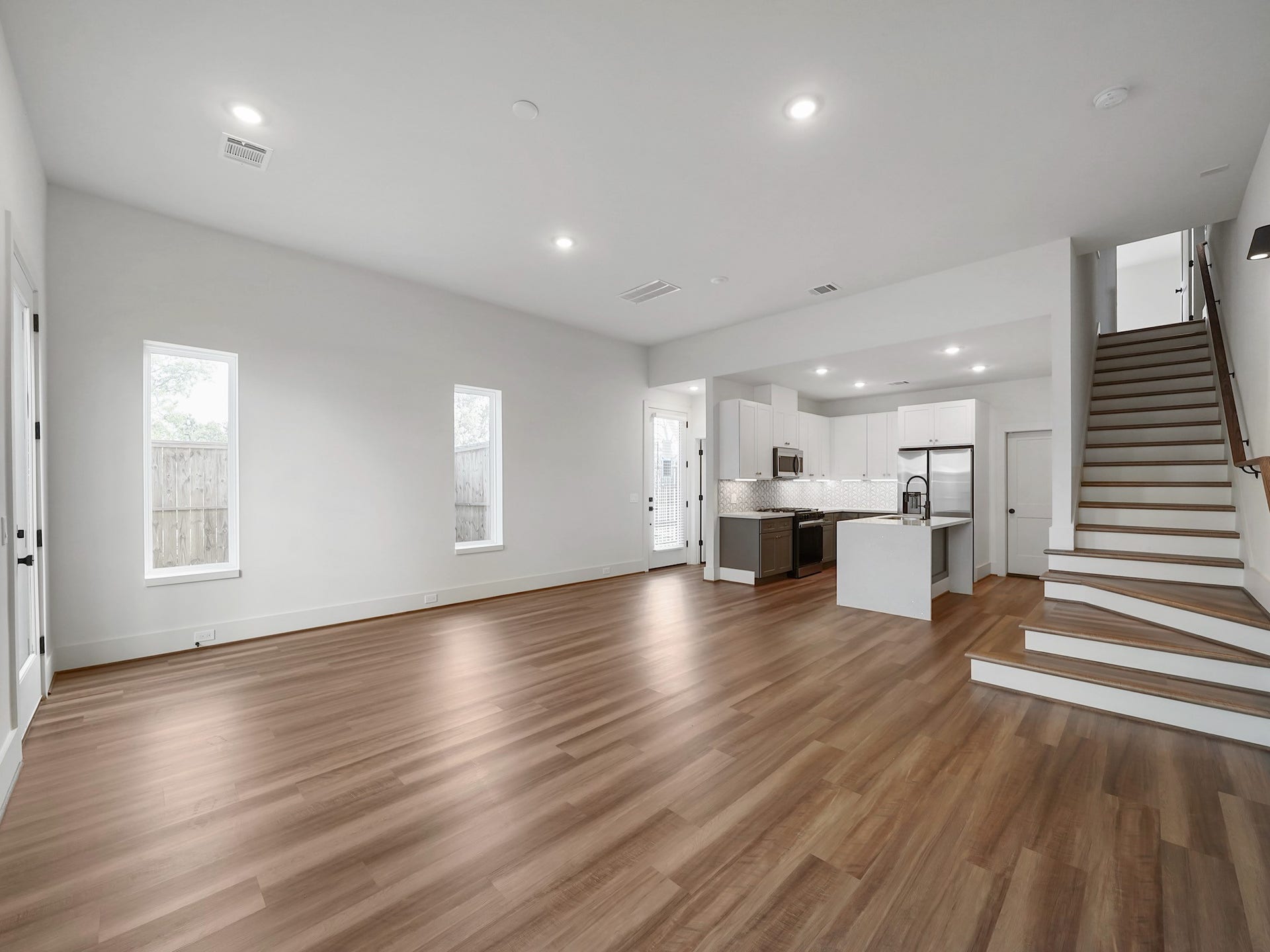 881 Rachel Street, #A, Houston, TX 77091 This spacious open-concept living area features modern wood flooring, abundant natural light from two tall windows, and a sleek kitchen with stainless steel appliances and a central island. A staircase provides access to the upper level.
Photo Disclaimer: Photos are representative of the community and may depict a similar floor plan, model home, or previously completed residence.