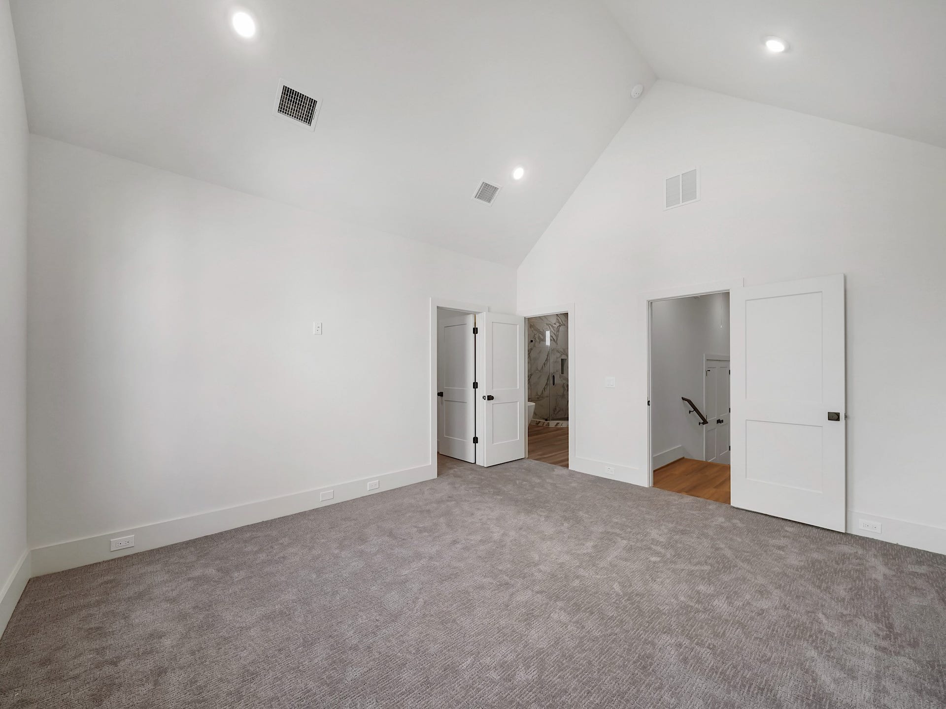 881 Rachel Street, #A, Houston, TX 77091 Spacious and bright room with high ceilings, carpet flooring, and recessed lighting. Features white walls, two doorways, and a visible staircase leading to another level.
Photo Disclaimer: Photos are representative of the community and may depict a similar floor plan, model home, or previously completed residence.
