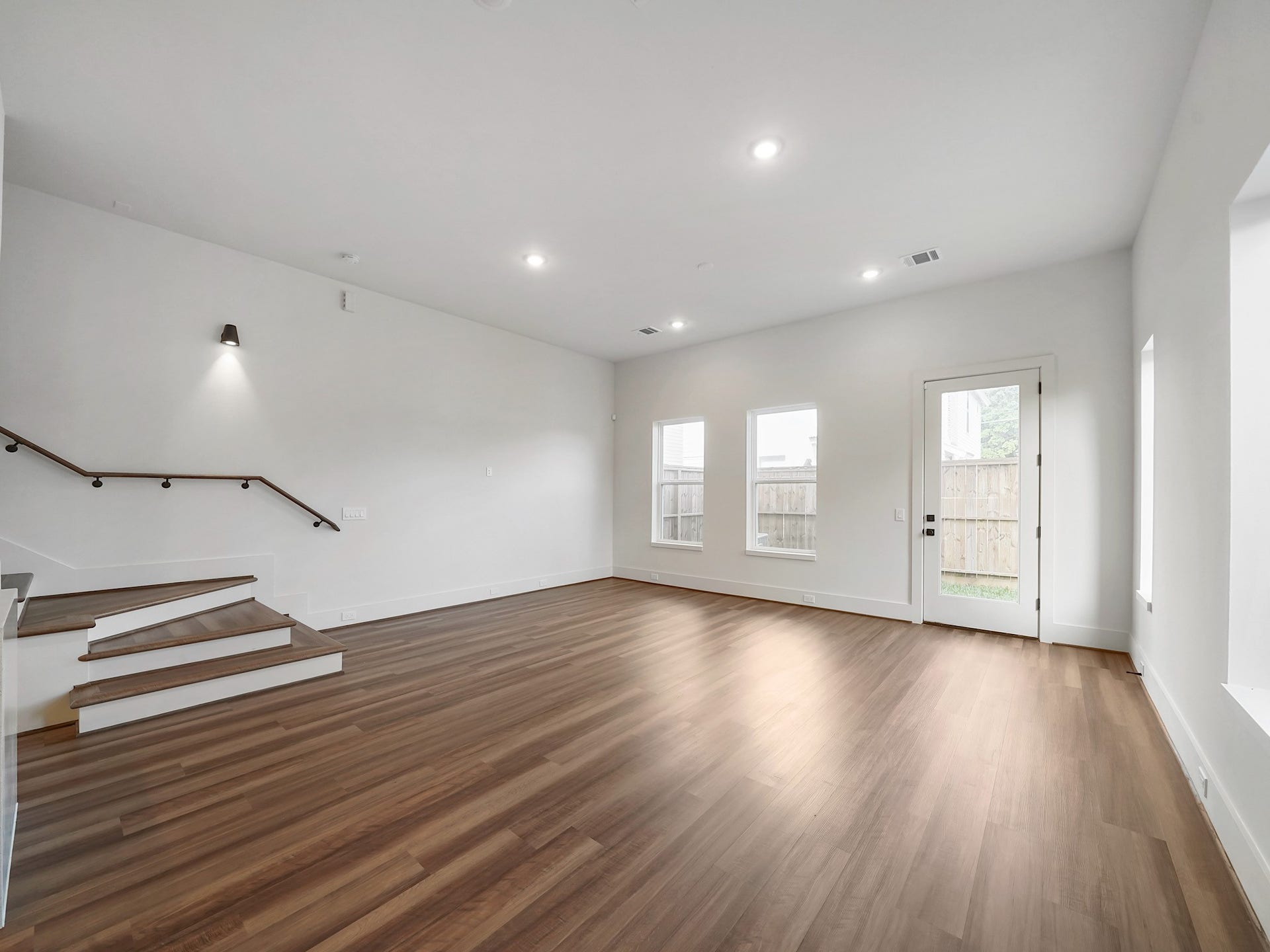 881 Rachel Street, #A, Houston, TX 77091 This spacious, bright living area features sleek hardwood floors and modern recessed lighting. Large windows and a glass door offer abundant natural light and outdoor access. A stylish staircase with a wooden handrail adds a contemporary touch.
Photo Disclaimer: Photos are representative of the community and may depict a similar floor plan, model home, or previously completed residence.