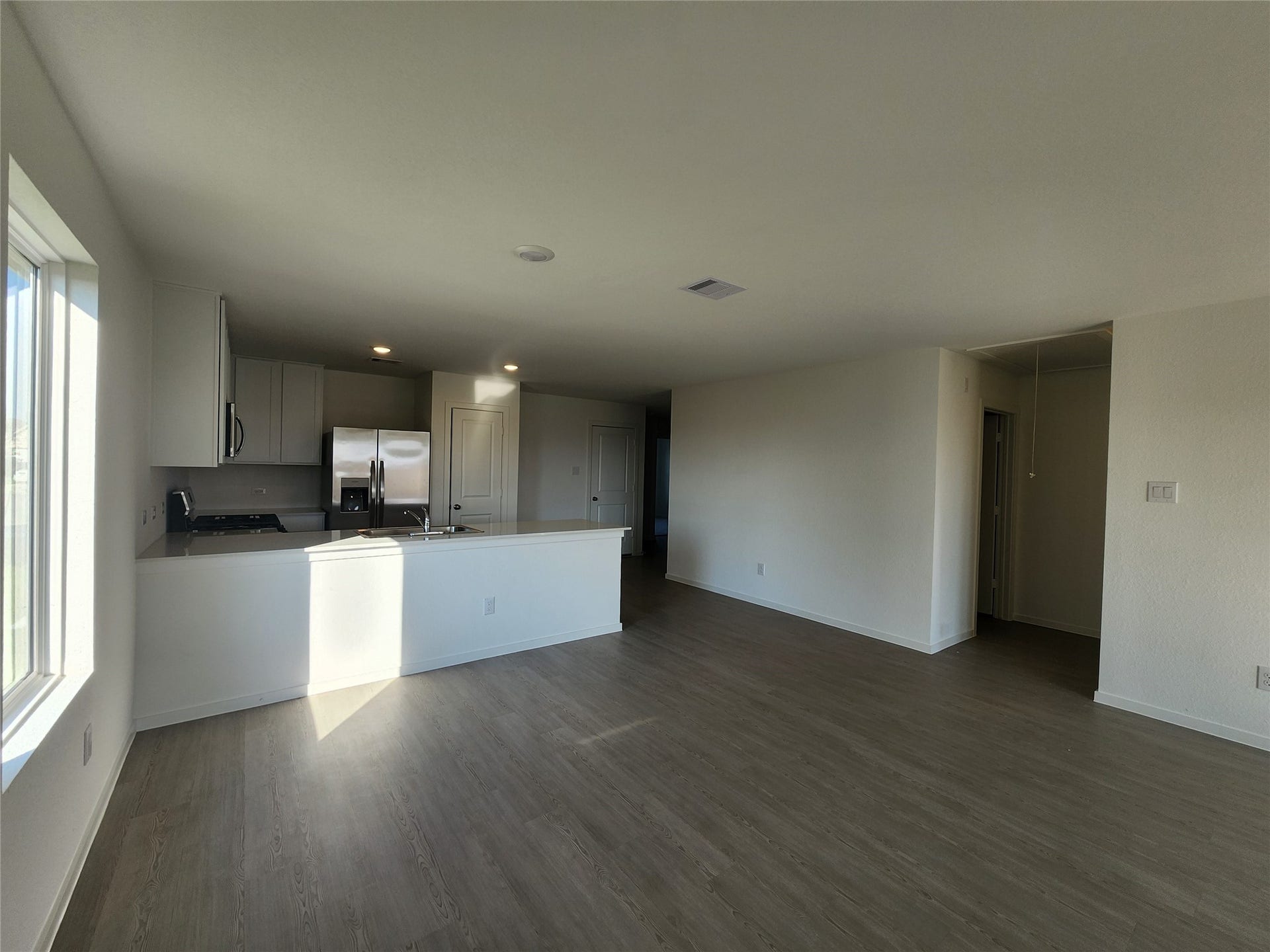 17307 Adina Creek Court, Crosby, TX 77532 View of kitchen/living area from backdoor. Entryway to the right leads to washer and dryer (included) as well as primary bedroom.