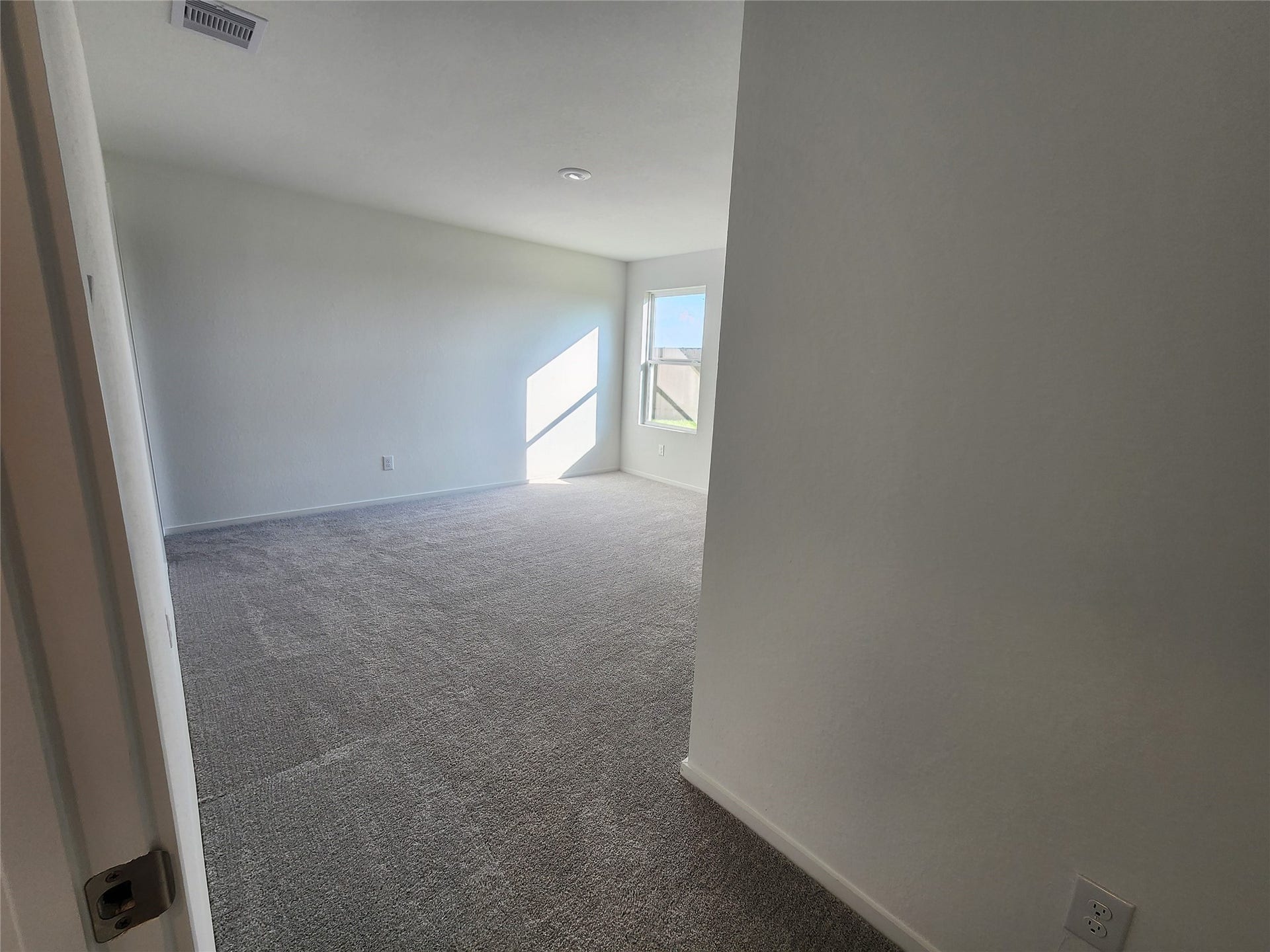 17307 Adina Creek Court, Crosby, TX 77532 Entryway to primary bedroom with carpet and a window that lets in plenty of natural light, creating a warm and inviting atmosphere.