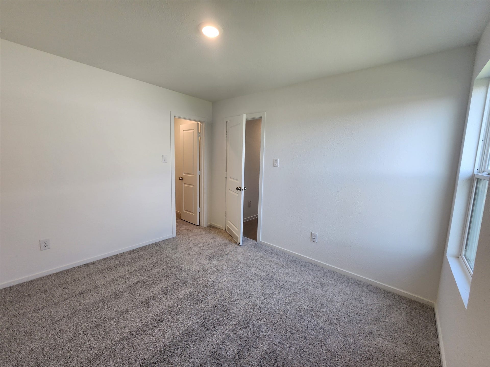 17307 Adina Creek Court, Crosby, TX 77532 Secondary bedroom with walk-in closet features soft carpeting and a large window for natural light.