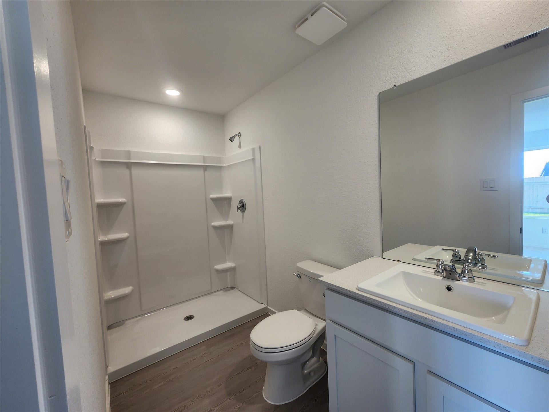 17307 Adina Creek Court, Crosby, TX 77532 Modern primary bathroom with a spacious walk-in shower, built in shelves, sleek fixtures, and a large mirror.