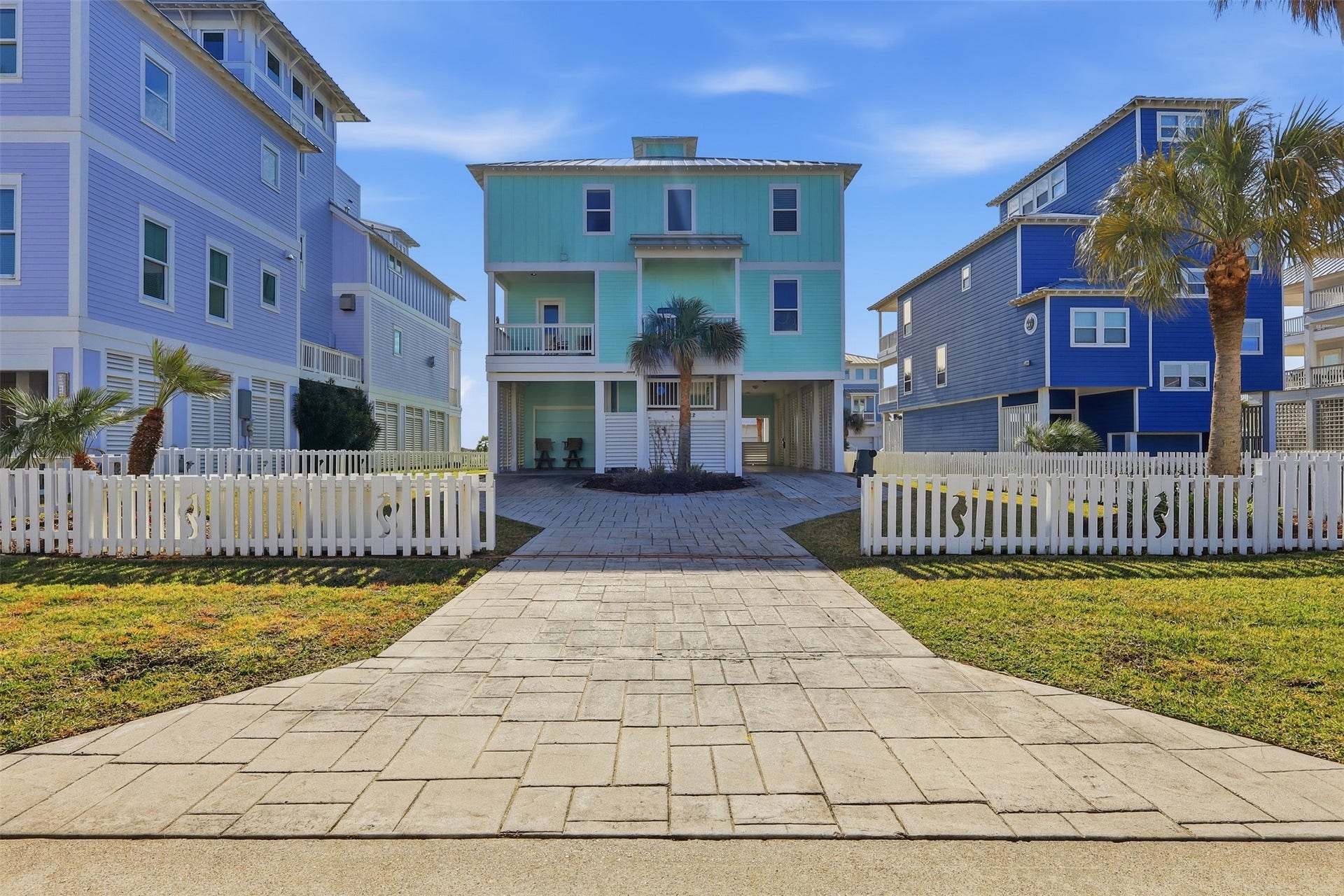 11622 Beachside, Galveston, TX 77554 A vibrant beach style home with multiple levels and a spacious balcony, offering a fully fenced yard and a gated driveway for added privacy and security.