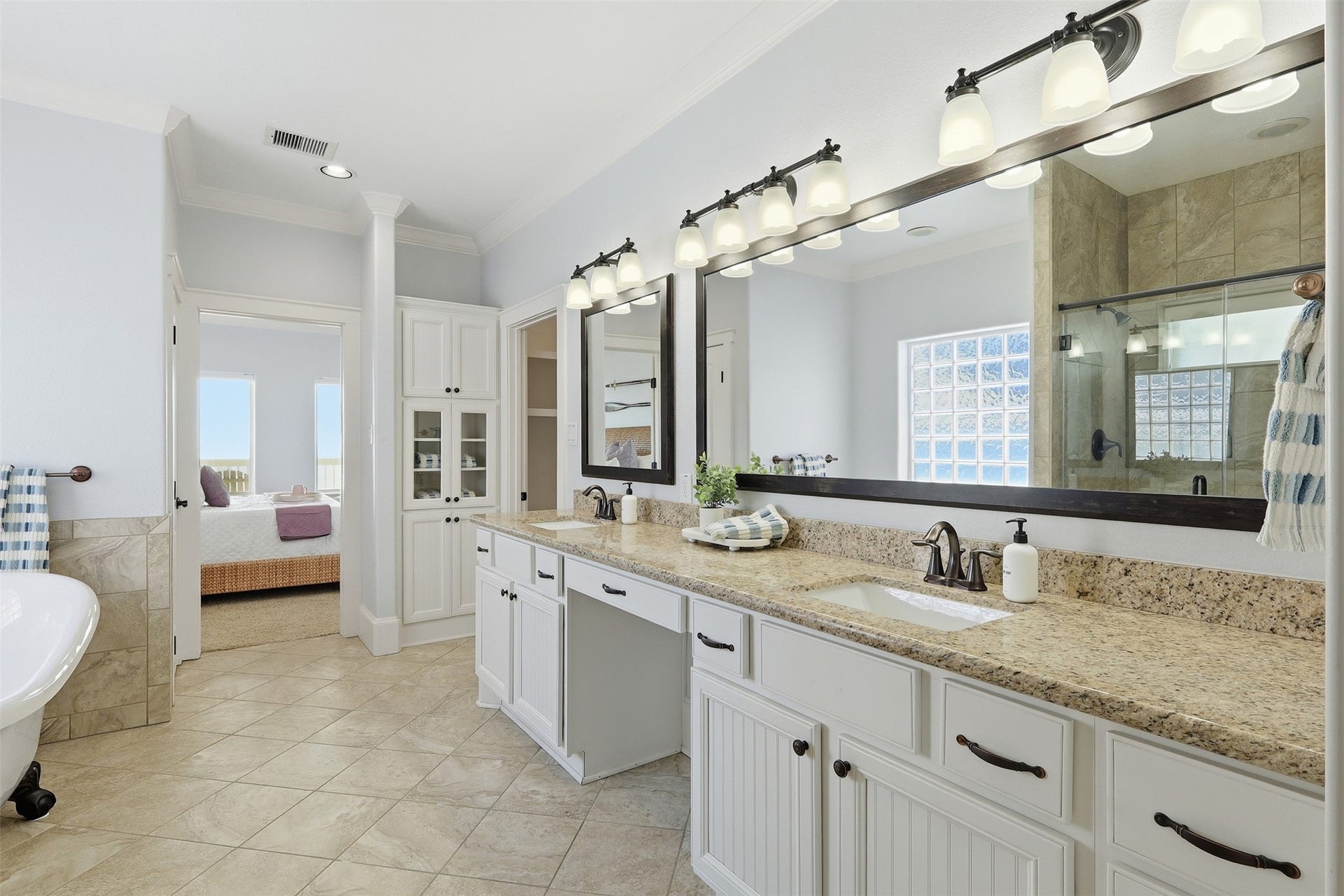 11622 Beachside, Galveston, TX 77554 This spacious bathroom features dual sinks with granite countertops, ample cabinet storage, and a large mirror all while having direct access to your primary suite.