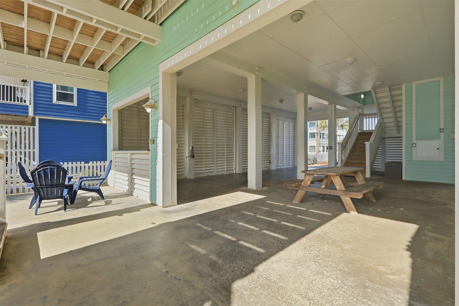 11622 Beachside, Galveston, TX 77554 A spacious, covered outdoor area with seating and a picnic table, featuring an open design.