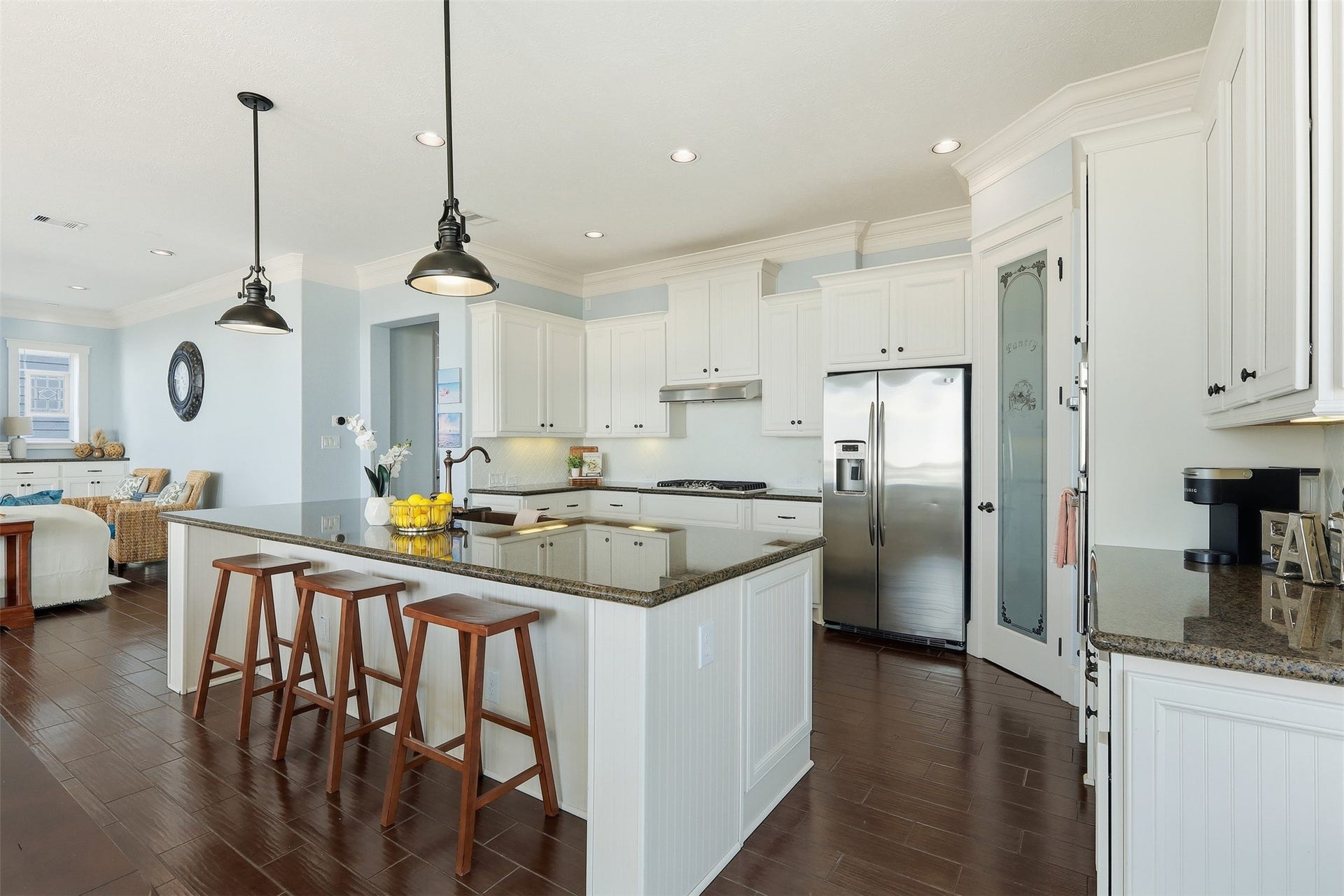 11622 Beachside, Galveston, TX 77554 This bright kitchen features sleek granite countertops, a large island with seating, stainless steel appliances, and ample white cabinetry.