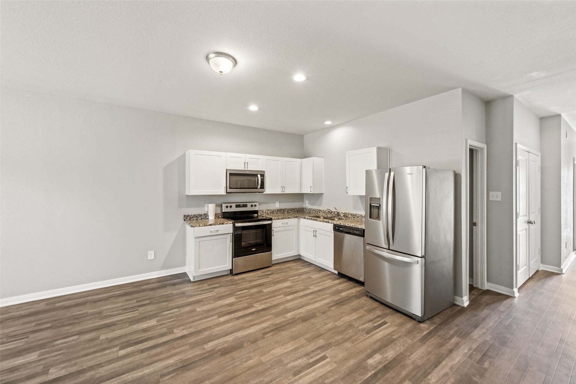 2537 18th Street, Hempstead, TX 77445 Open-concept living, dining, and kitchen area featuring durable flooring, recessed lighting, and a bright, modern layout.