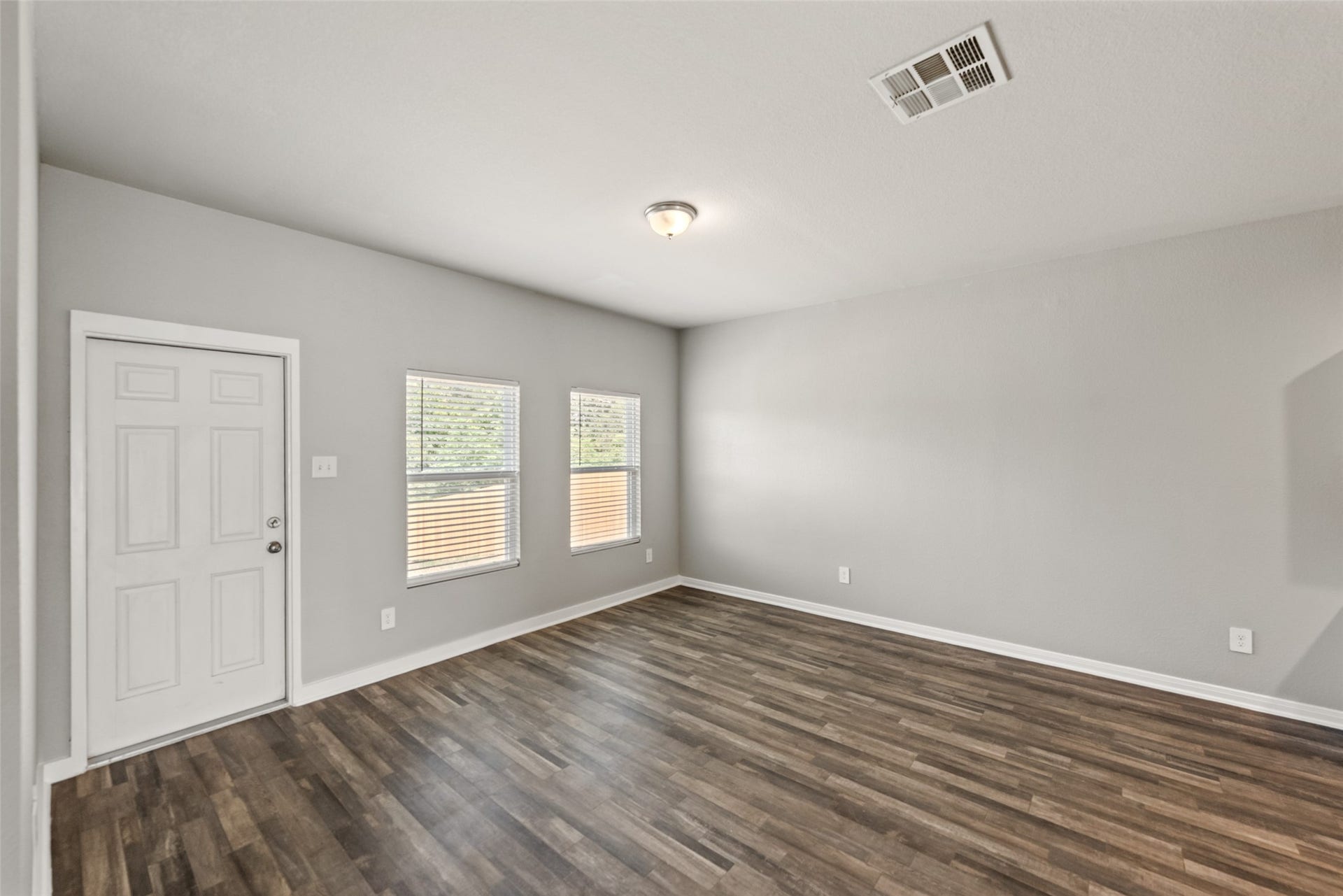 2537 18th Street, Hempstead, TX 77445 Spacious living area featuring durable wood-look flooring, neutral finishes, and multiple windows providing natural light.