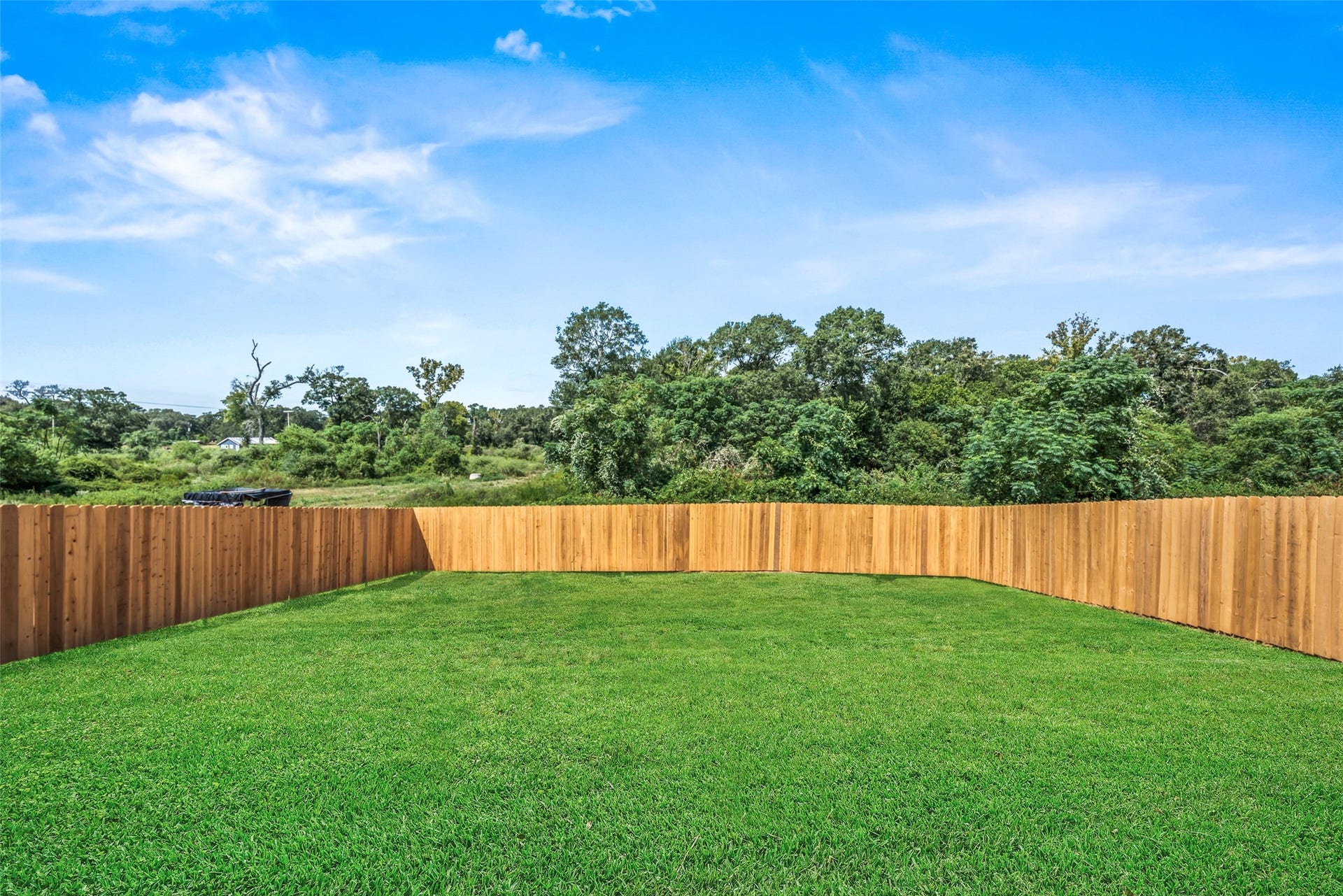 2537 18th Street, Hempstead, TX 77445 Additional backyard view showcasing the expansive green space, privacy fencing, and open outdoor setting.