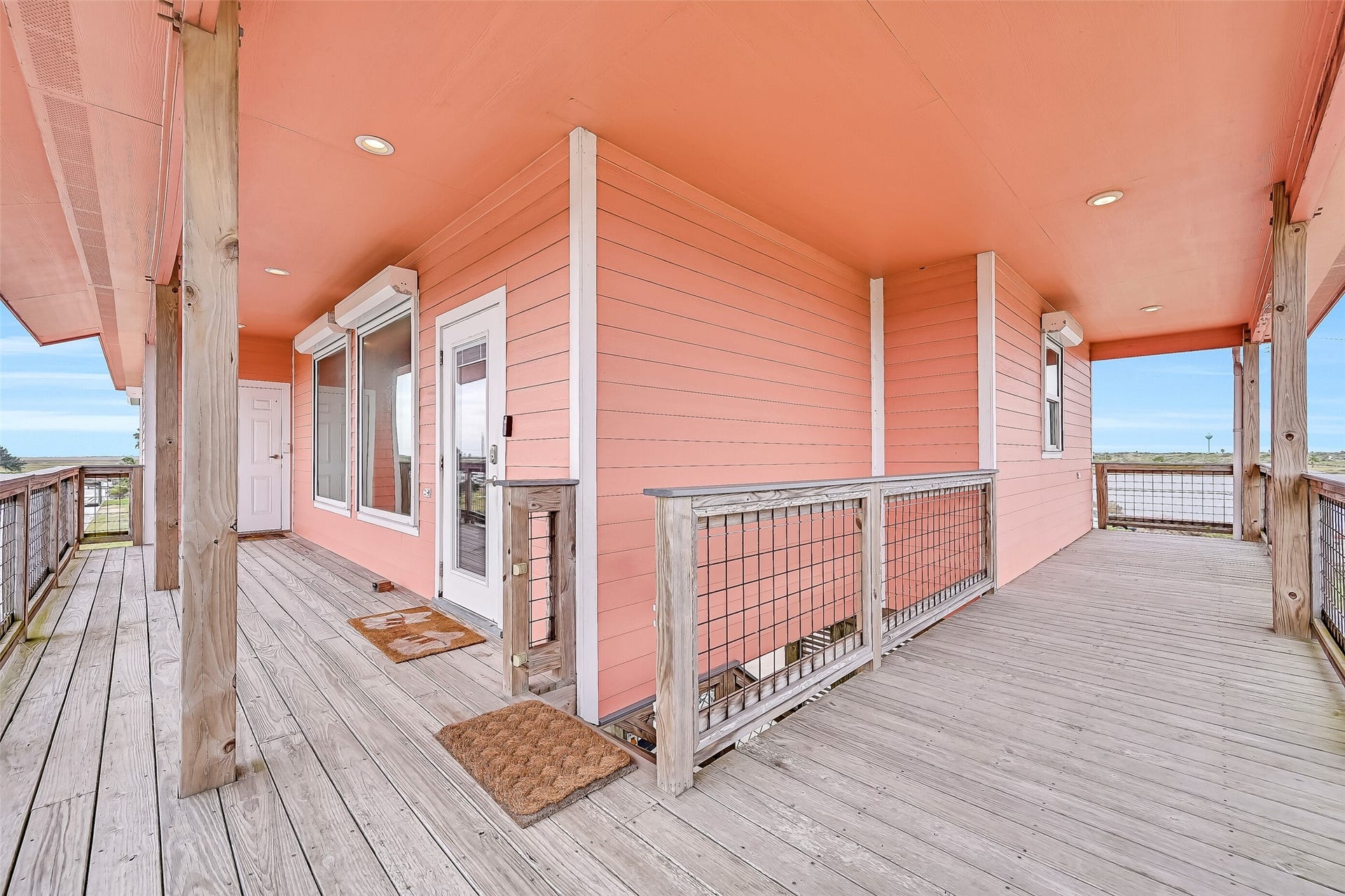 7119 Beau Rue Street, Hitchcock, TX 77563 Enjoy fabulous sunrises and sunsets from the comfort of your covered deck. Even the stairs leading to the main level are covered and lead directly to the covered entertaining / parking areas under the home. The 6 panel door to the left of the picture windows access a full elevator and not just a cargo lift- yes that is right! This home offers the ultimate in accessibility thanks to a residential elevator.