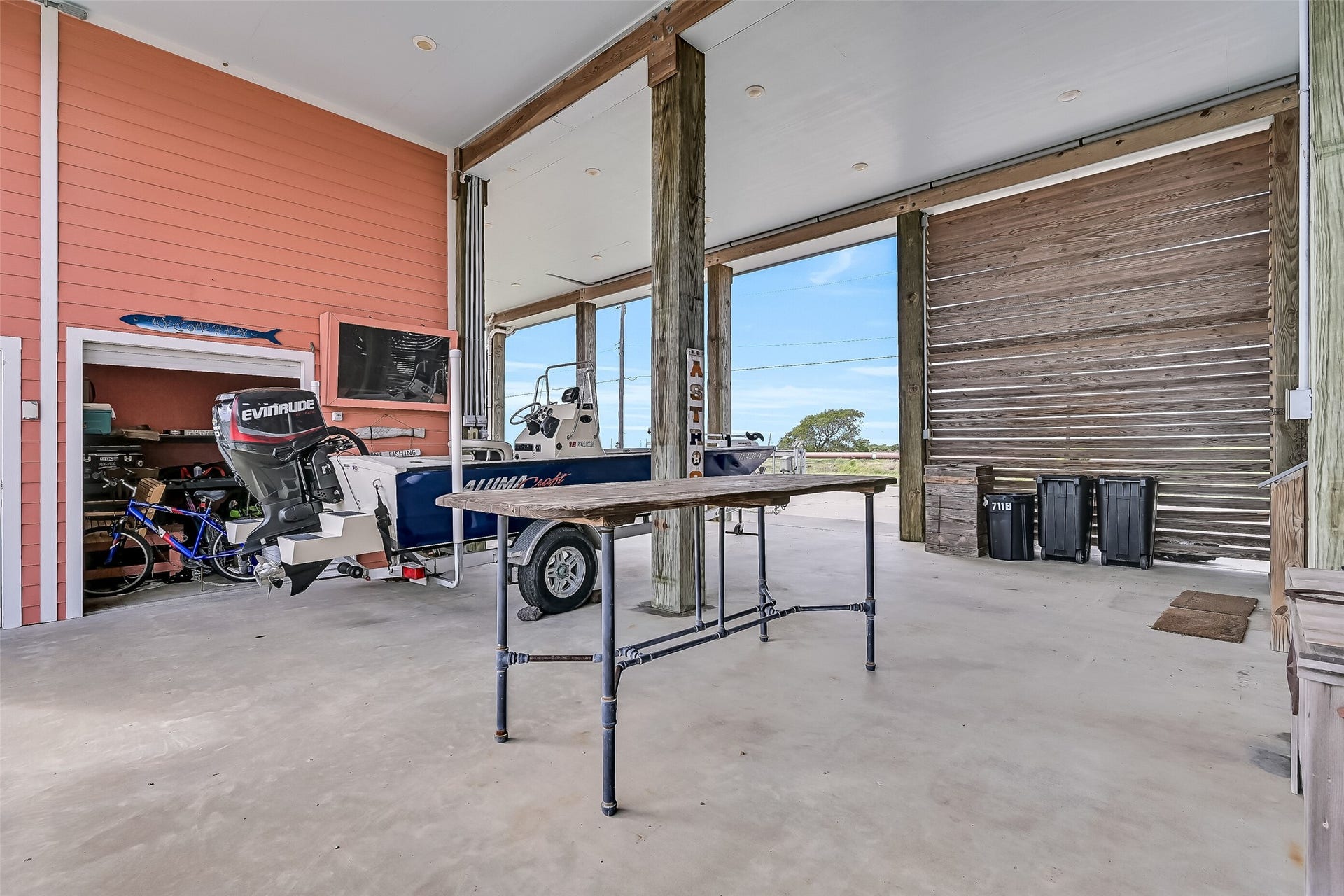 7119 Beau Rue Street, Hitchcock, TX 77563 Open the shutter door to reveal a storage room, with a work space.