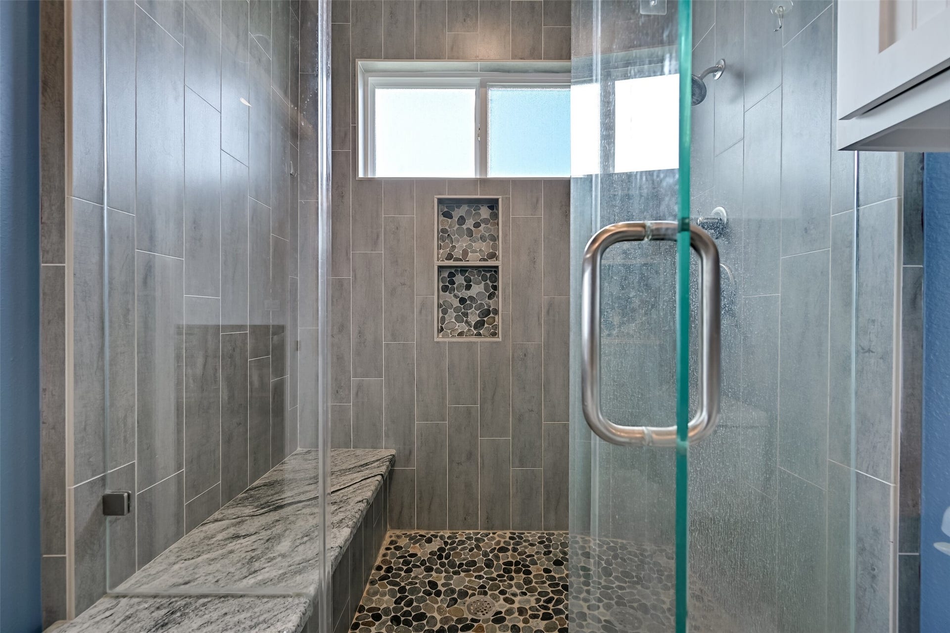 7119 Beau Rue Street, Hitchcock, TX 77563 This spa-like walk in shower showcases a frameless glass enclosure, pebble floor, and convenient bench lathed with granite. Notice the double shower niches.