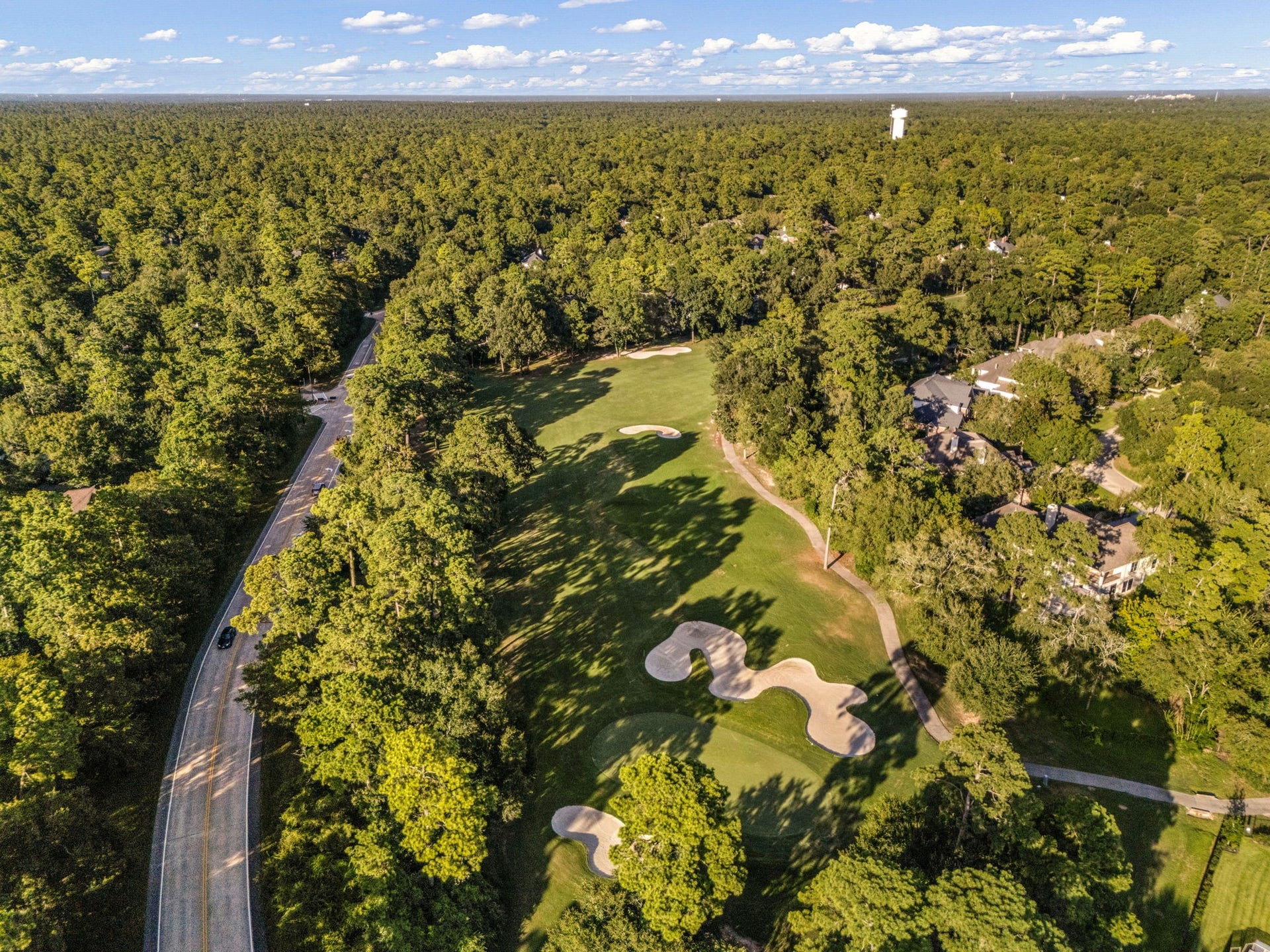205 Purple Slate Place, The Woodlands, TX 77381 An incredible high-altitude view captures the true essence of living in this highly sought-after section of The Woodlands. Bordered by the scenic Cochrans Crossing Drive, the Palmer Courses distinctive sand bunkers stretch across the green landscape, completely surrounded by a sea of mature pines.
