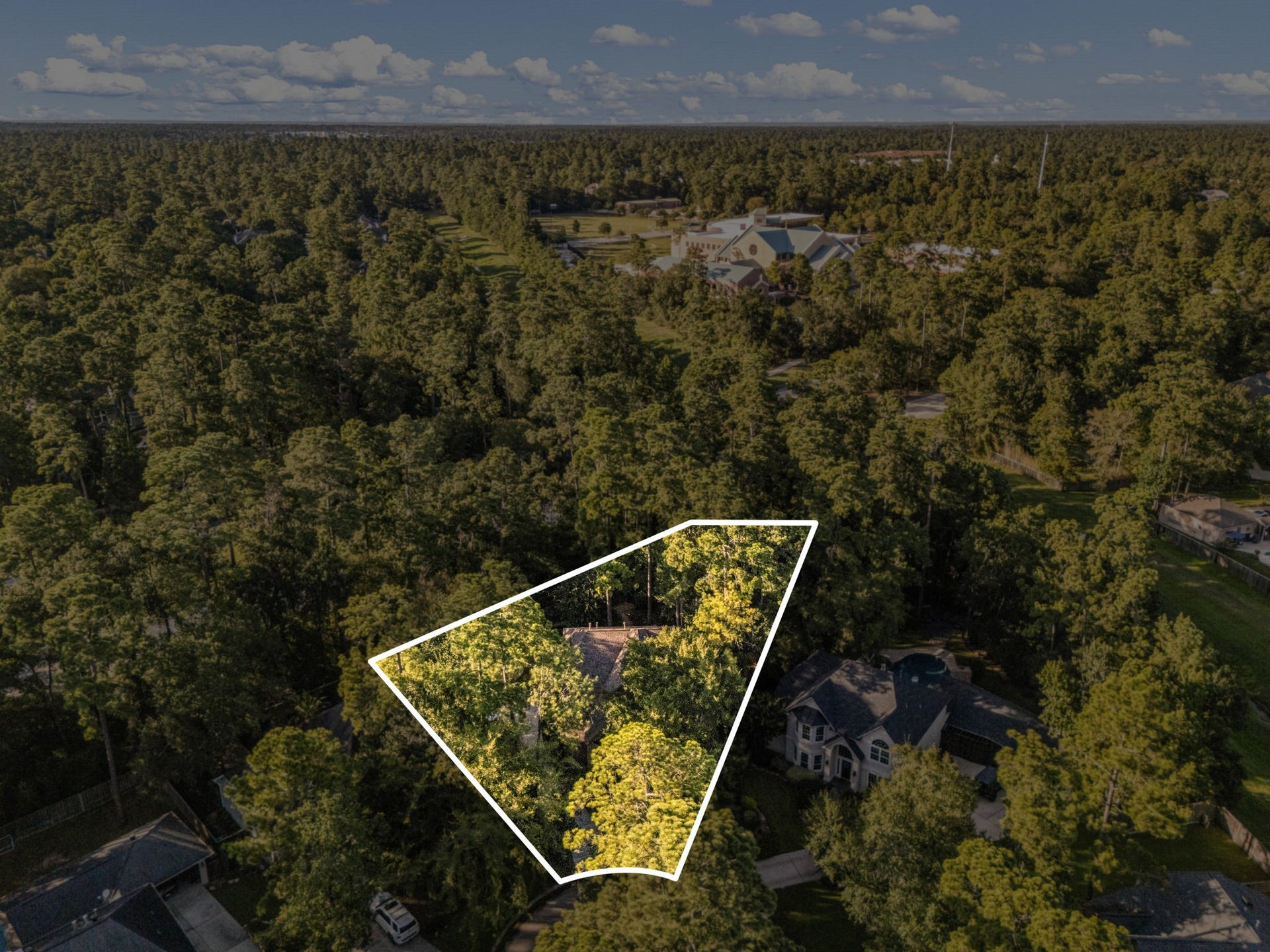 205 Purple Slate Place, The Woodlands, TX 77381 This expansive aerial view perfectly illustrates the premium lifestyle offered at 205 Purple Slate Pl, situated directly across the beautiful Palmer Golf Course. The home enjoys a completely private, wooded buffer while remaining just steps away from world-class fairways, local lakes, and pristine country club amenities.