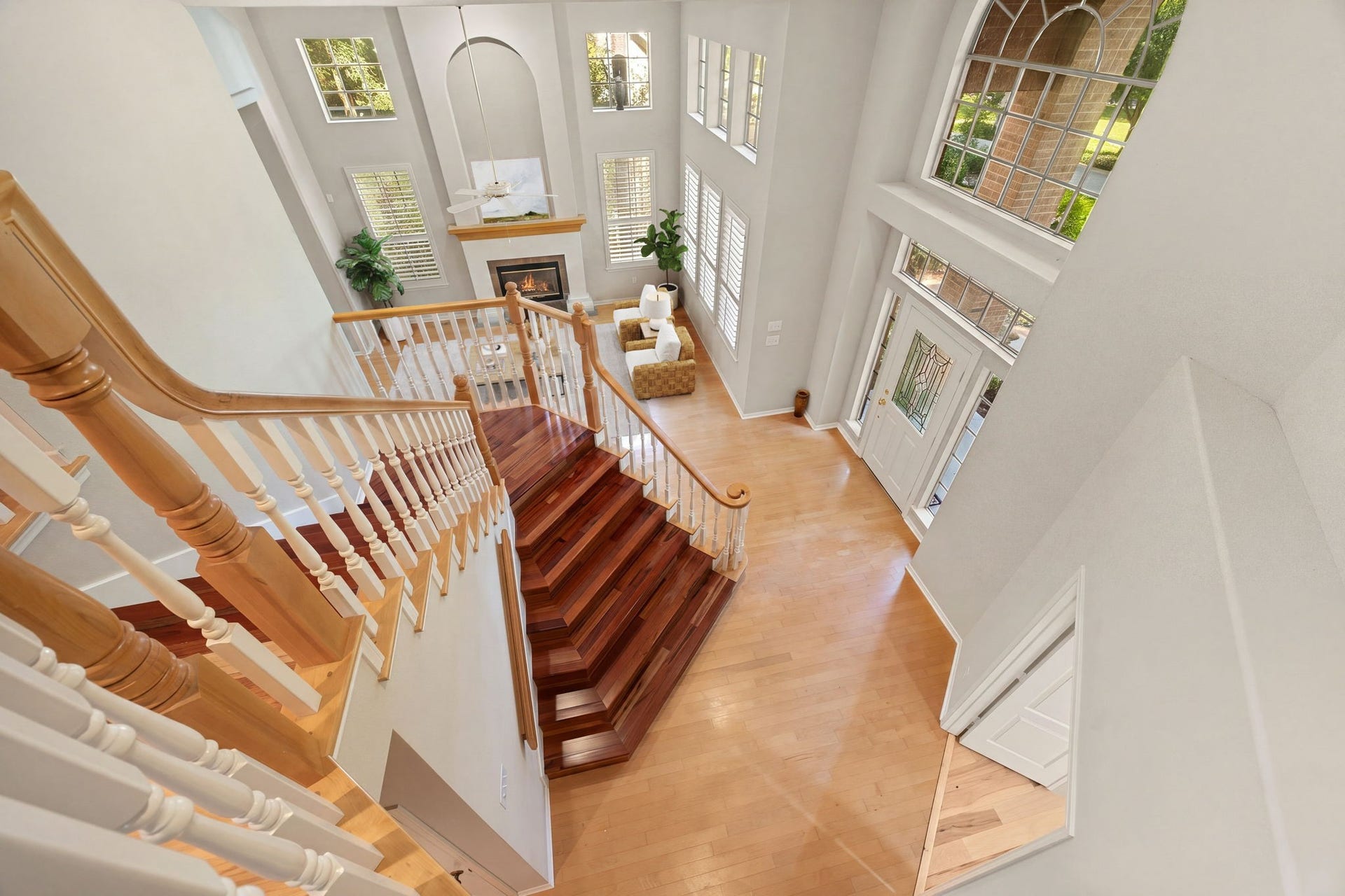 205 Purple Slate Place, The Woodlands, TX 77381 This commanding view from the landing highlights the spectacular architectural volume of the soaring, two-story grand entry and family room. Richly polished hardwood steps cascade down the sweeping staircase, accented by crisp white spindles and warm wood banisters that border the upper walkway. *Virtually Staged