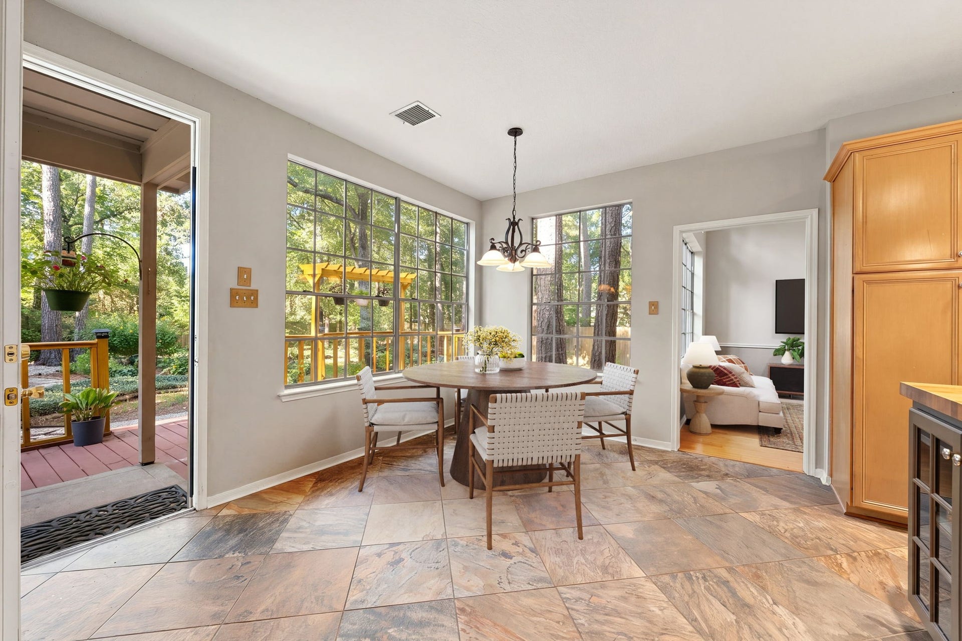 205 Purple Slate Place, The Woodlands, TX 77381 Bask in natural light and tranquil nature views in this bright, open breakfast nook located just off the kitchen. The spacious layout transitions beautifully to the backyard through a wide glass patio door, while a separate interior doorway links the space to the formal living areas. High ceilings, crisp neutral paint, and rich, earthy floor tiles combine to create a warm and highly inviting atmosphere for everyday meals. *Virtually Staged