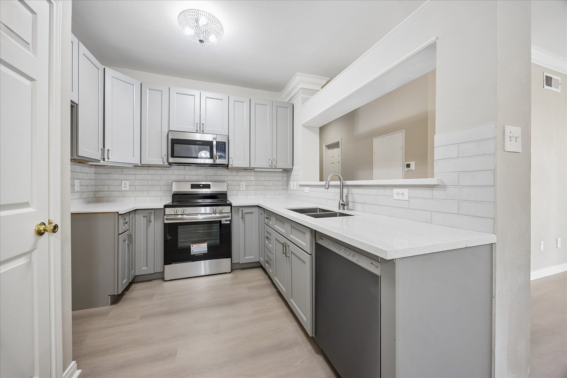 3231 Allen Parkway, #1216, Houston, TX 77019 Beautifully updated kitchen featuring white countertops, subway tile backsplash, gray shaker-style cabinetry w/ soft-close drawers & cabinets, brushed nickel hardware & stainless steel appliances. Fabulous combination of style & functionality! Generous countertop space & stainless steel appliances including Frigidaire electric range, built-in microwave & Bosch dishwasher. under-cabinet lighting, double-basin undermount stainless steel sink w/ gooseneck faucet & pantry closet w/ built-in shelving.