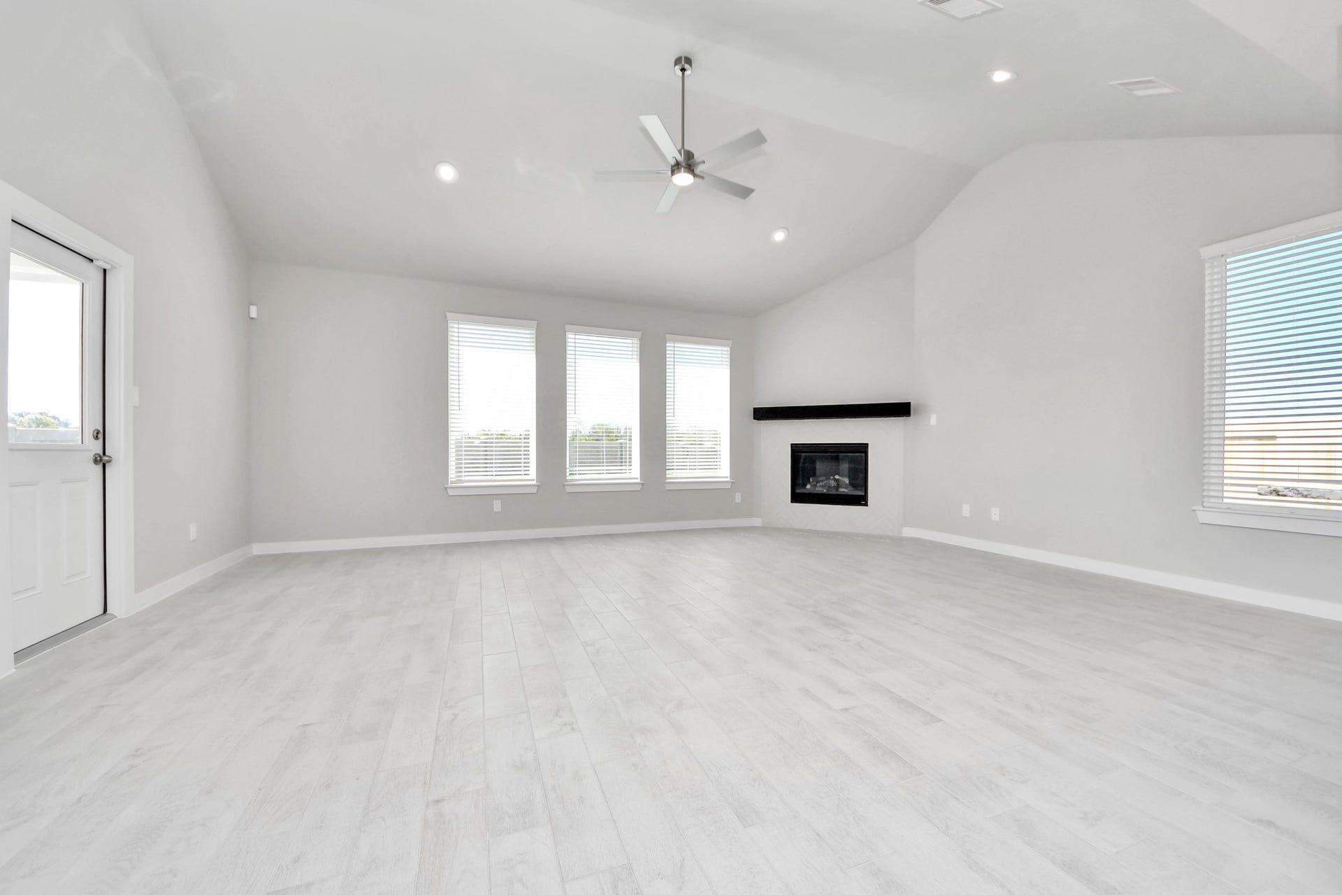 Welcome family and guests to your charming living room! With its high ceilings, recessed lighting, ceiling fan, custom paint, beautiful flooring, and large windows that let in abundant natural light, this room is perfect for gatherings. Sample photo of completed home with similar floor plan. Actual colors and selections may vary.