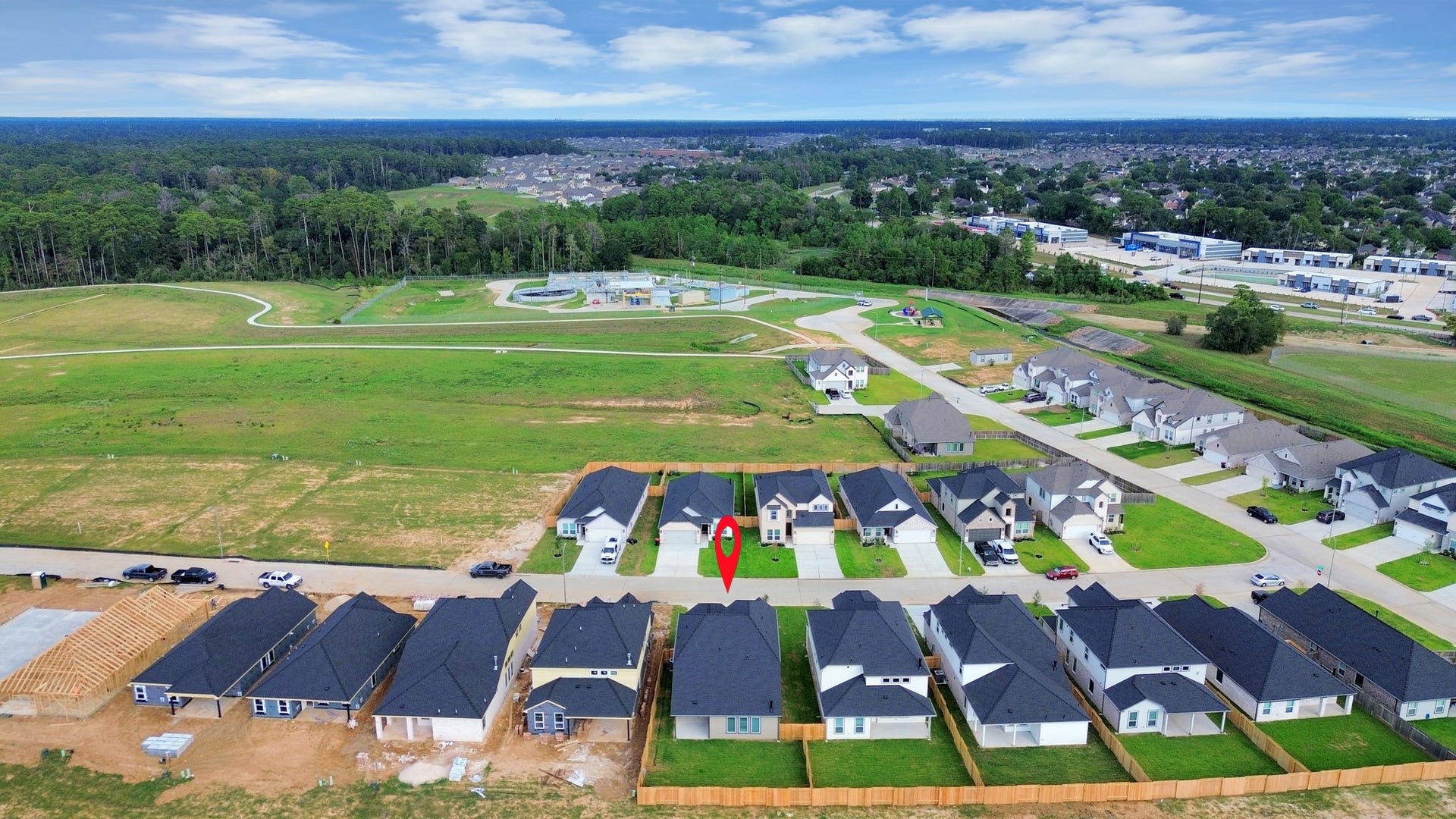An aerial view of a spacious subdivision lot, highlighting a well-maintained yard and a fully fenced perimeter, offering both privacy and expansive outdoor space.