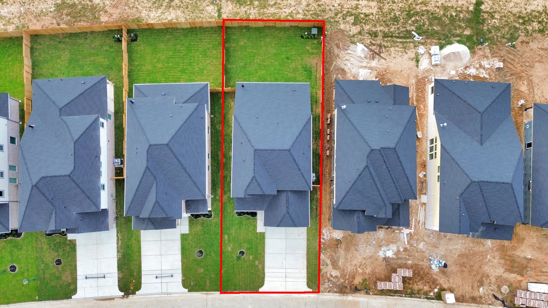 An aerial view of a spacious subdivision lot, highlighting a well-maintained yard and a fully fenced perimeter, offering both privacy and expansive outdoor space.