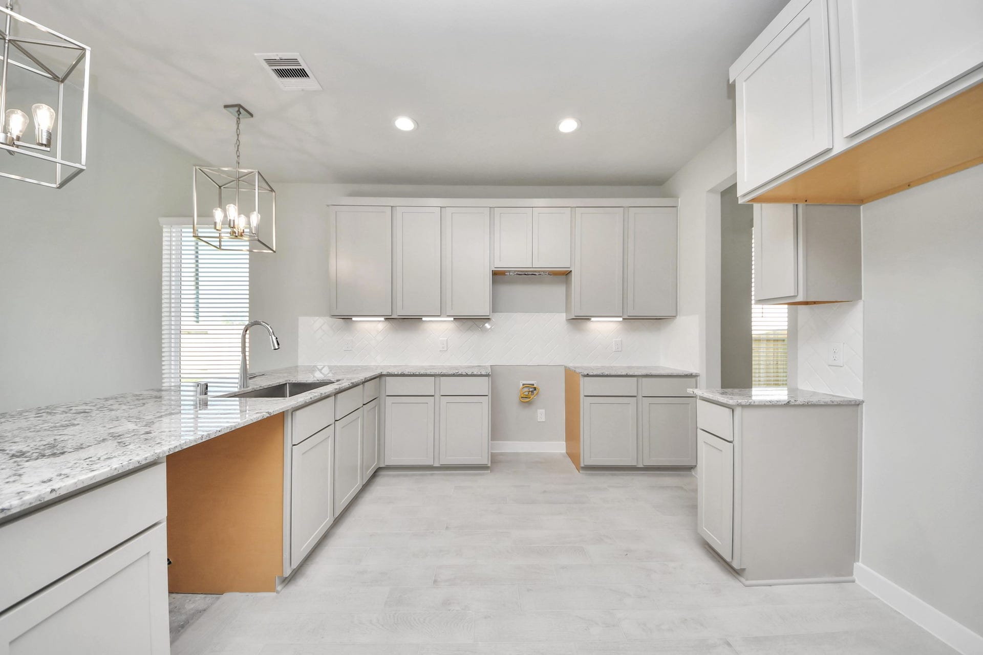 The kitchen is a culinary haven, featuring granite countertops, a tile backsplash, stainless steel appliances, 42 upper cabinets, and undercabinet lighting. Sample photo of completed home with similar floor plan. Actual colors and selections may vary.