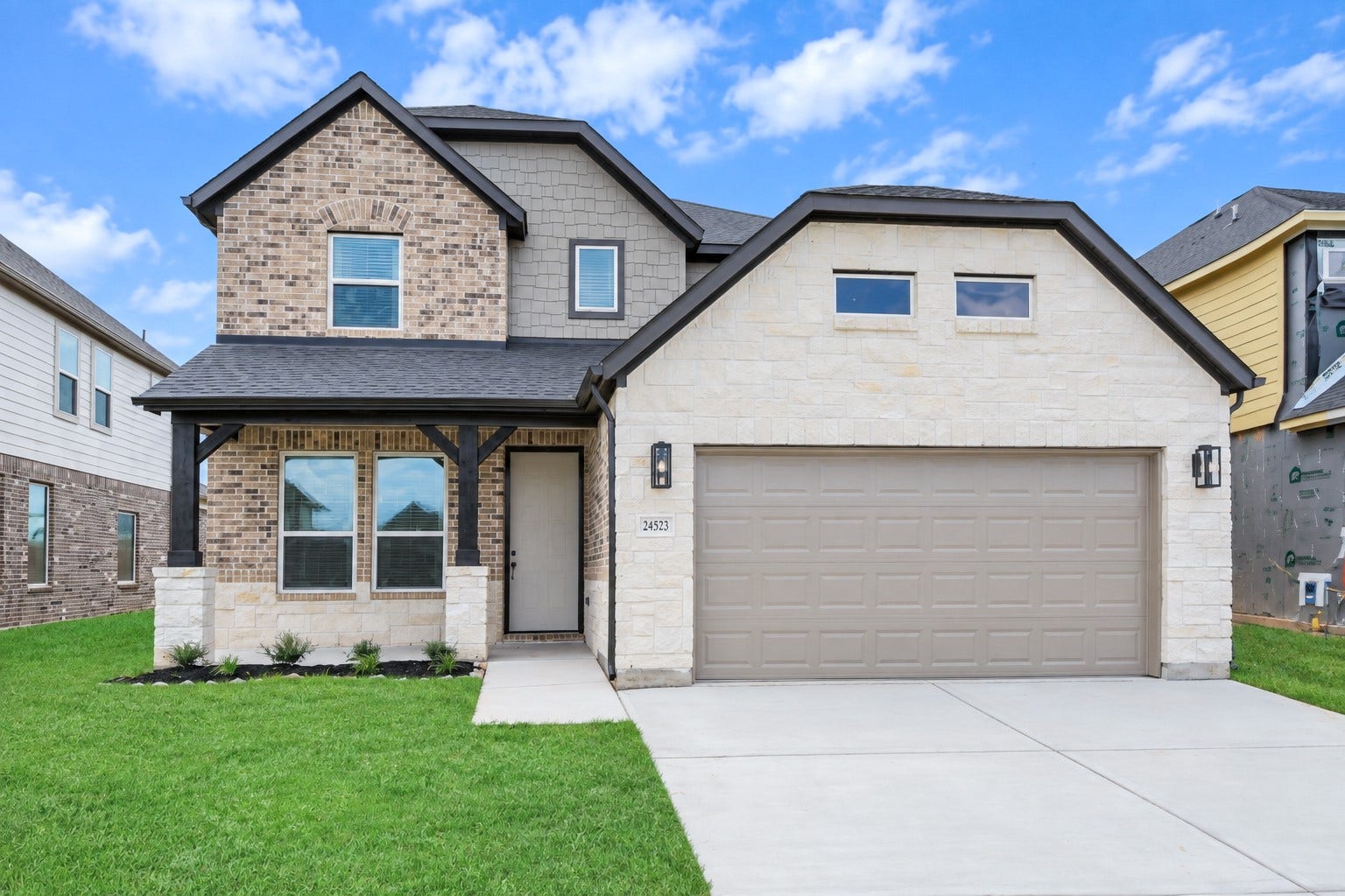 This home boasts lush green grass and meticulous landscaping. Its premium elevation showcases an exquisite blend of brick and stone features, complemented by modern coach lighting