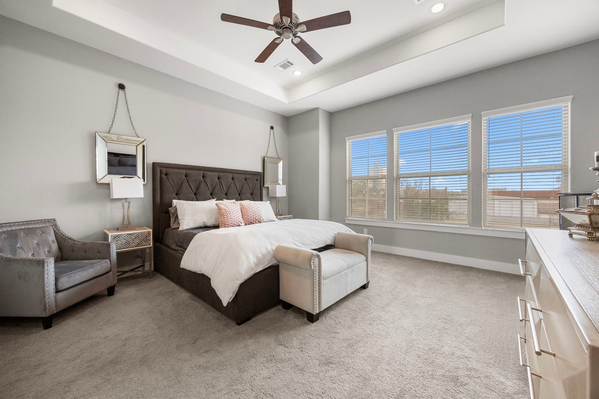 1216 Murrayhill Drive, Houston, TX 77043 Experience luxury in the primary bedroom with an elegant tray ceiling and a stylish ceiling fan.