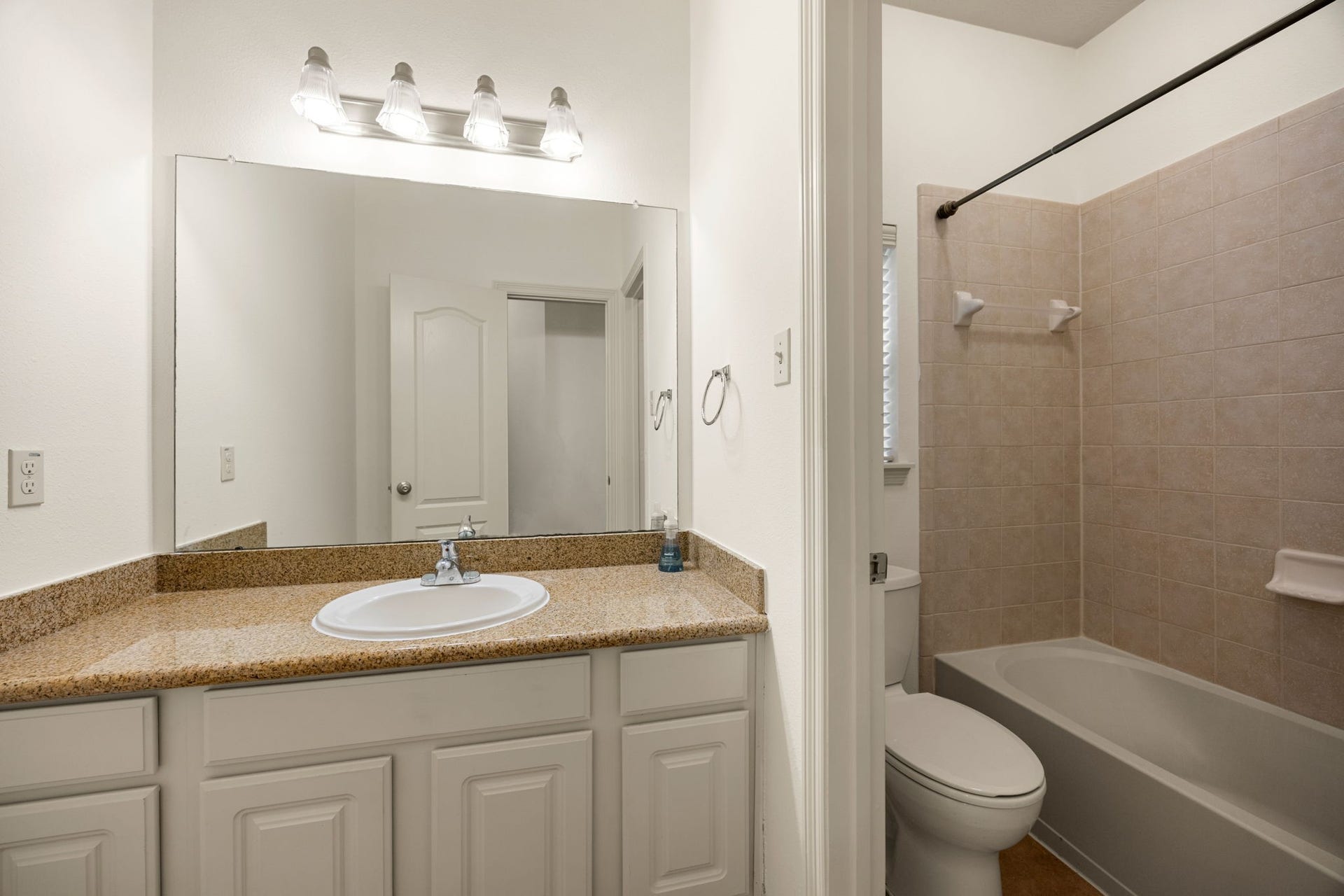 9430 Amethyst Arbor Lane, Katy, TX 77494 This secondary bathroom features a highly functional layout designed to streamline busy mornings, showcasing a white vanity with granite countertop, tub/shower combination with tile surround, and tile flooring.