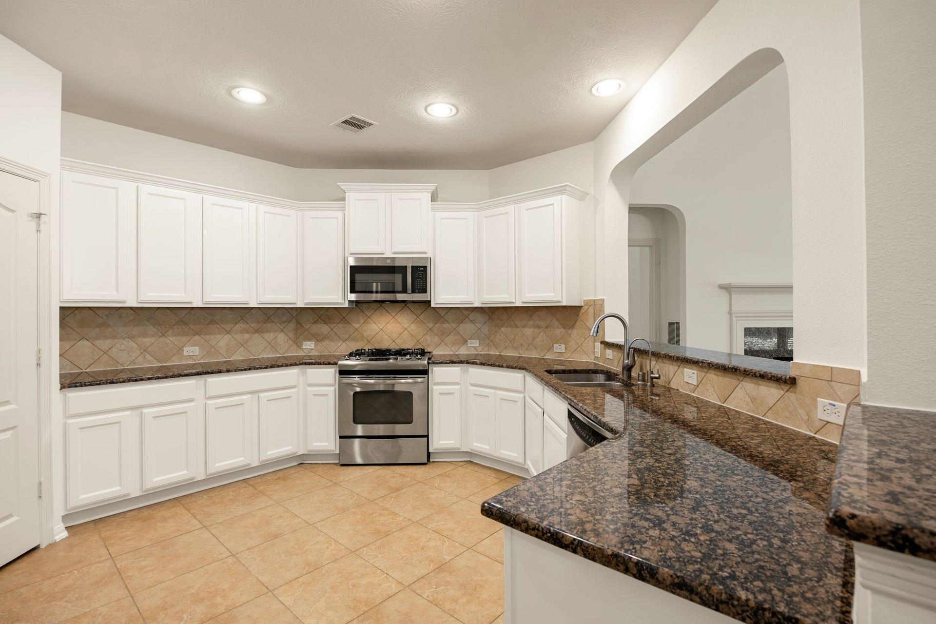 9430 Amethyst Arbor Lane, Katy, TX 77494 This beautifully designed kitchen combines bright, open space with exceptional functionality, featuring an abundance of crisp white cabinetry and expansive granite countertops.