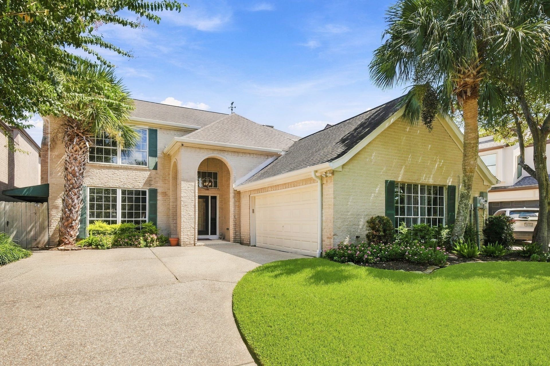 932 Plantation Street, League City, TX 77573 The front elevation features a classic brick exterior, an arched entry, and a double-wide driveway.