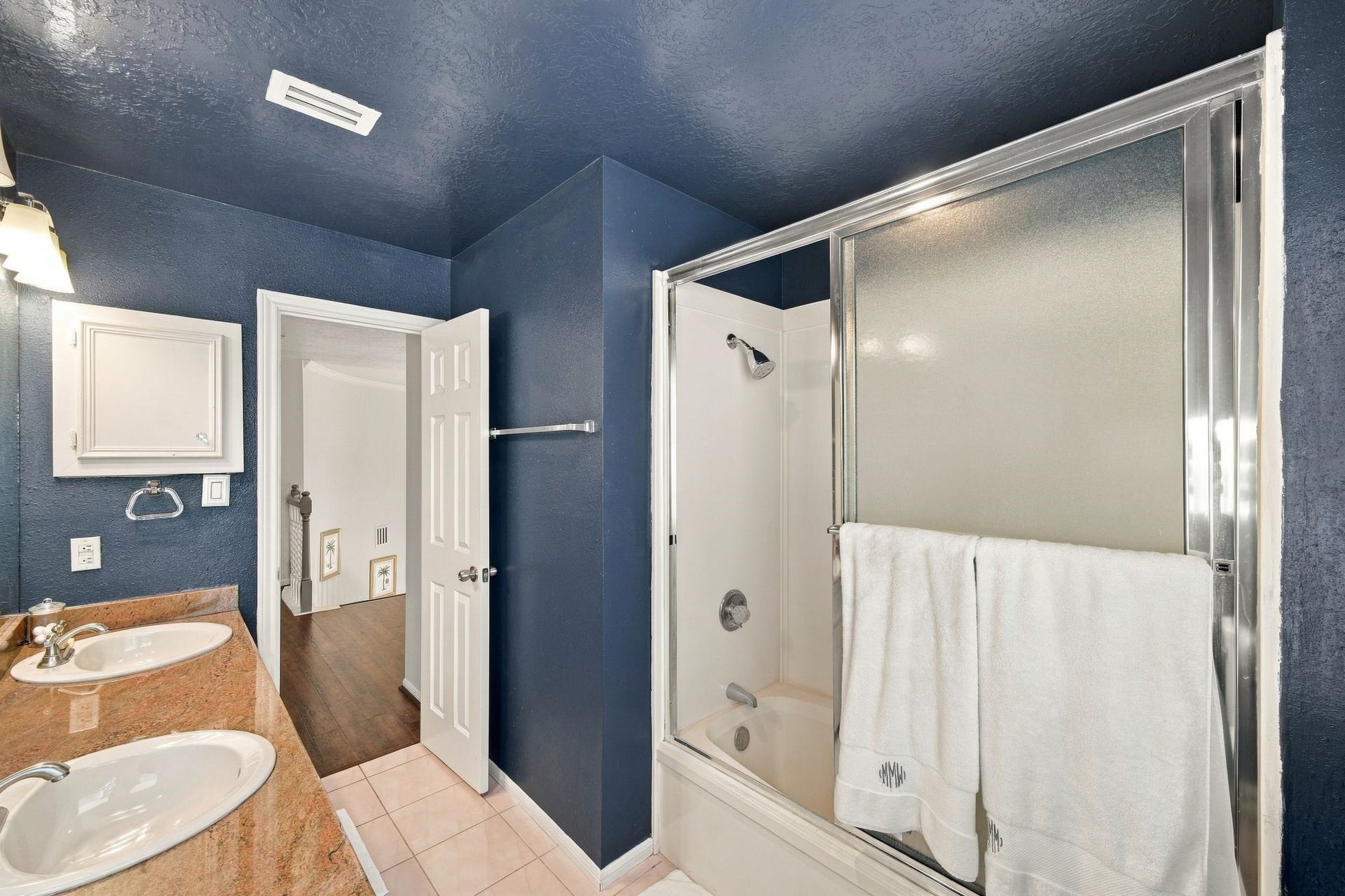 932 Plantation Street, League City, TX 77573 The secondary bath has bold navy accent walls and a tub and shower combination.