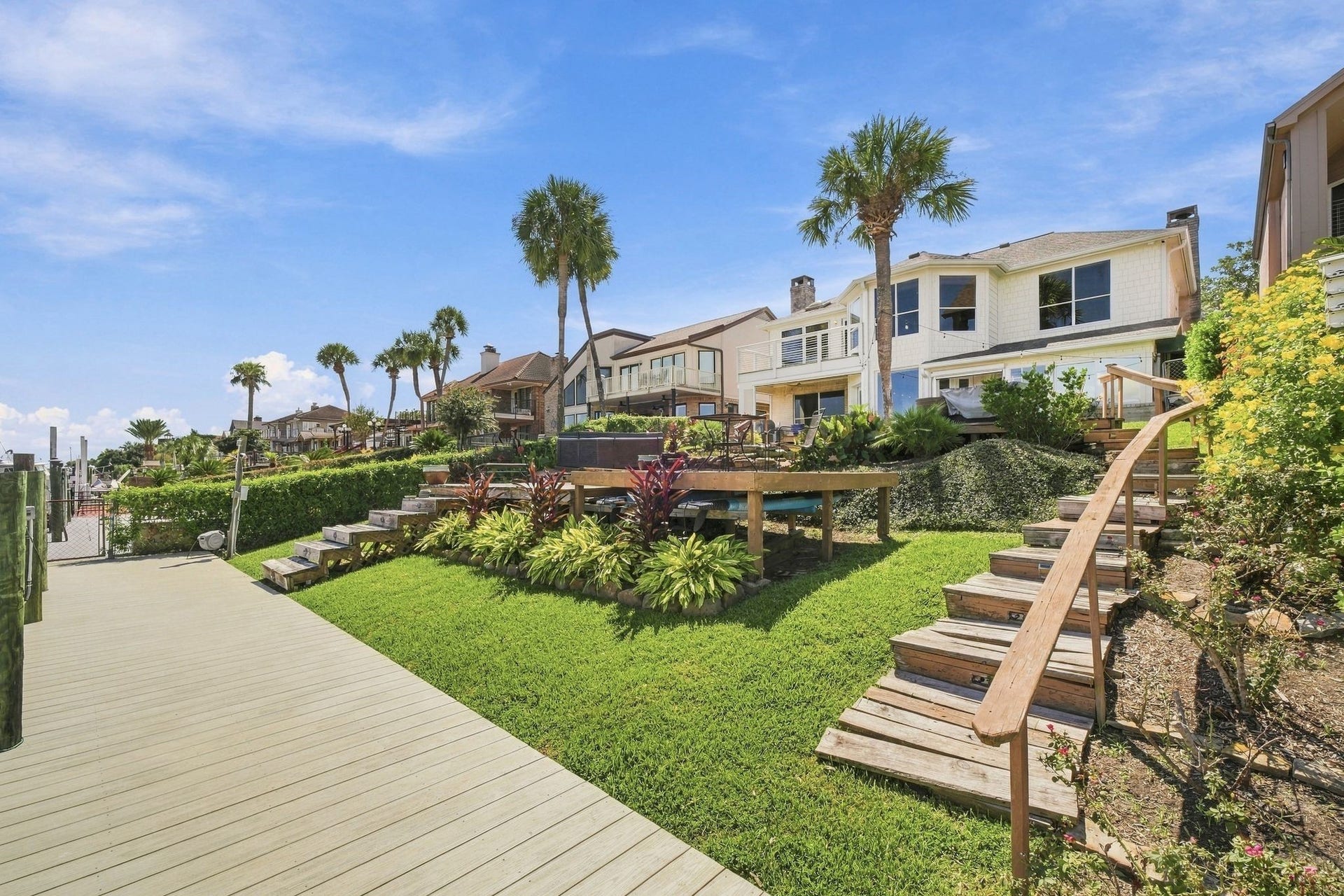932 Plantation Street, League City, TX 77573 Terraced landscaping and wooden steps lead from the water up to the home.