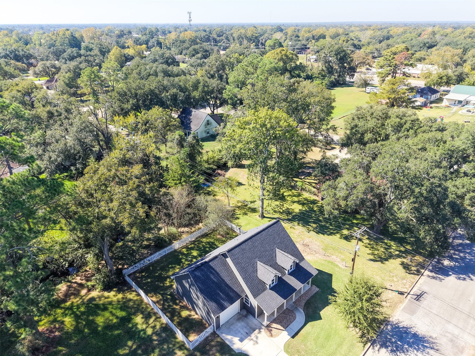 1125 Galveston Street, Hempstead, TX 77445 Aerial view highlighting the homes tree-lined setting, surrounding lawn, and nearby neighborhood.
